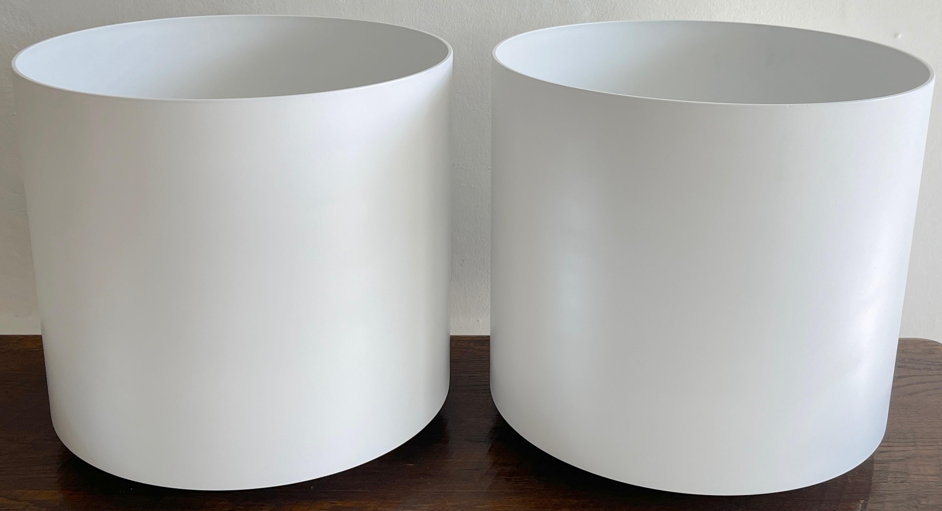 Pair of Italian Modern white lacquered fiberglas planters, Each one a sleek circular drum with tapering pedestal 14.5 Inch diameter base, with numerous drain holes. 
    