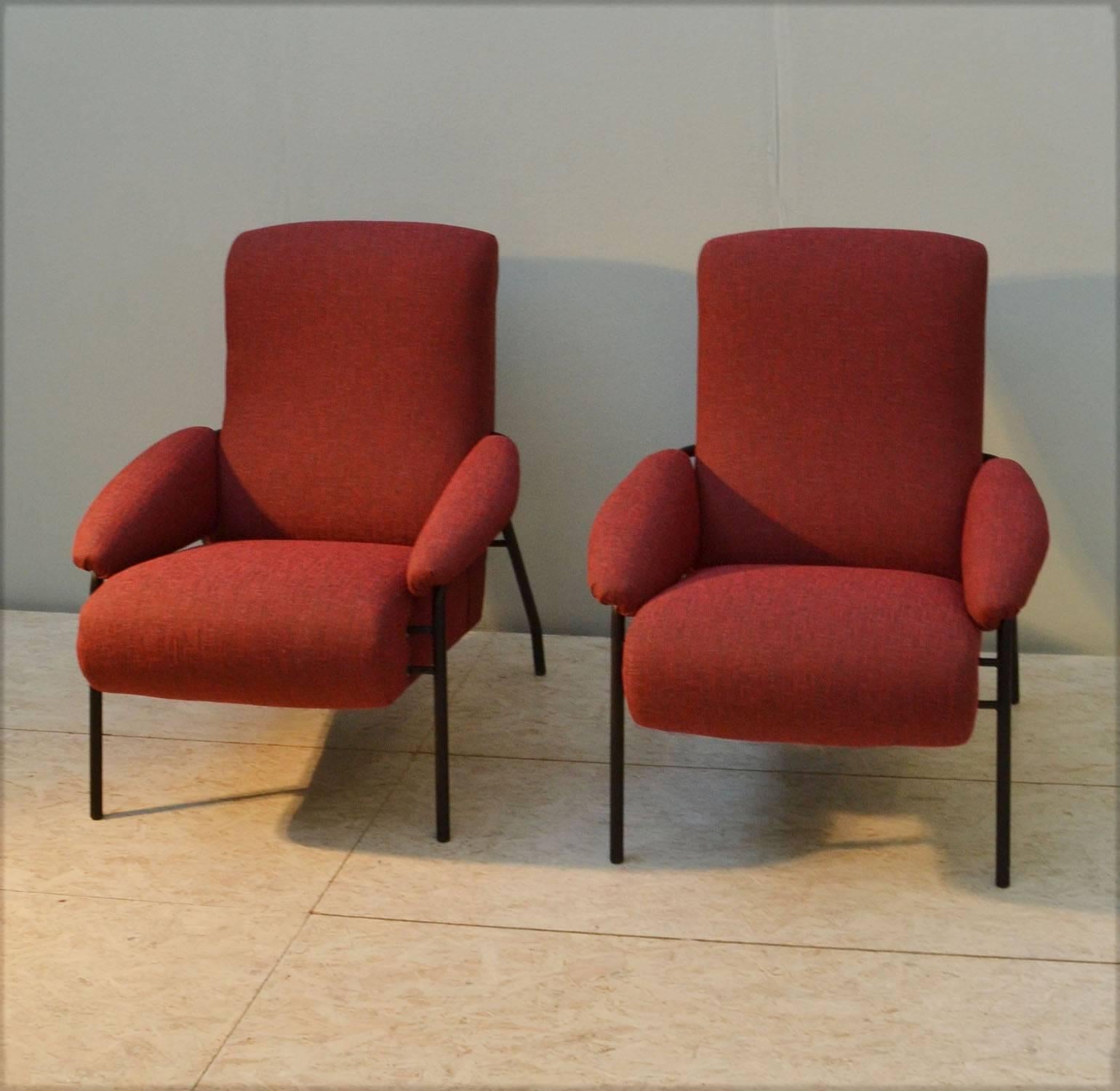 Mid-Century Modern pair of Italian lounge chairs. The armchairs sit in a black metal frame with brass details and are reupholstered in burnt orange fabric. 
They are extremely comfortable understated chairs.
