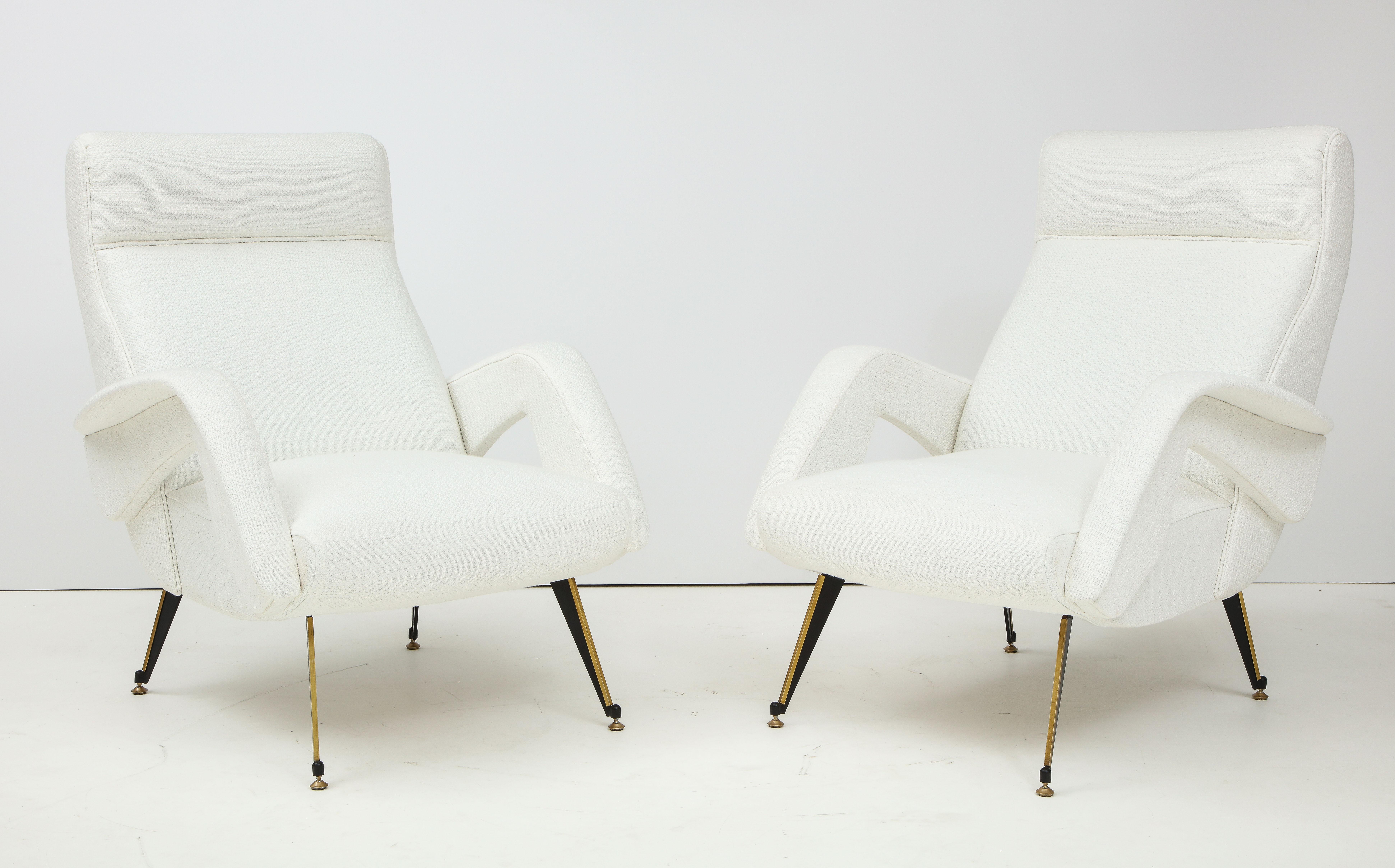 A pair of Italian modernist sculptural armchairs with open arms and reclined backs. Supported on brass and metal splayed legs. Extremely comfortable and elegant, newly re-upholstered in Italian textured white cotton. 
Italy, circa 1960 
Size: 36