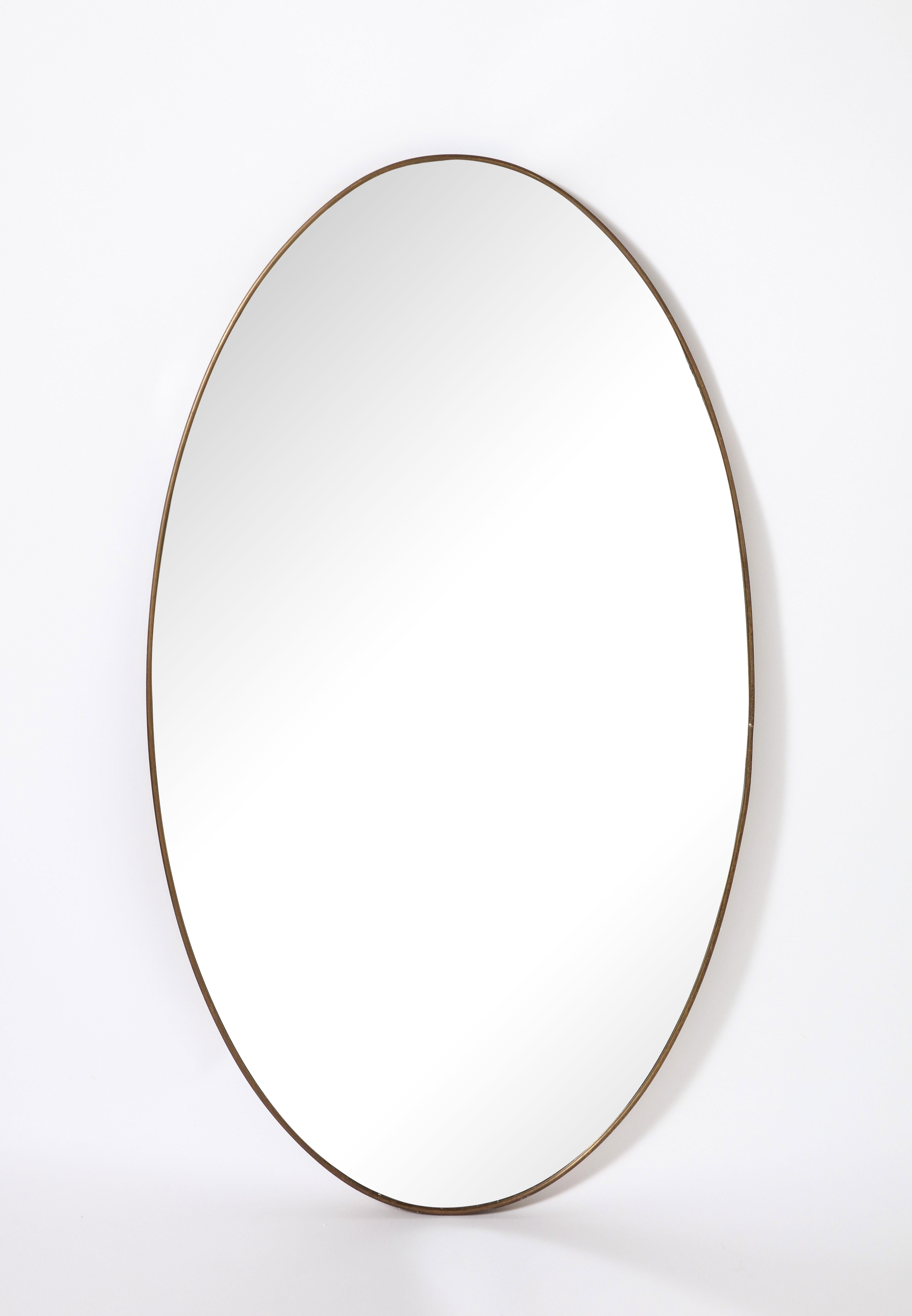 Ovale Messingspiegel der italienischen Moderne; eine wunderbare Form, das Messing mit originaler warmer und reicher Patina. Original Spiegelglasplatte. 
Italien, um 1950 
Größe: 49