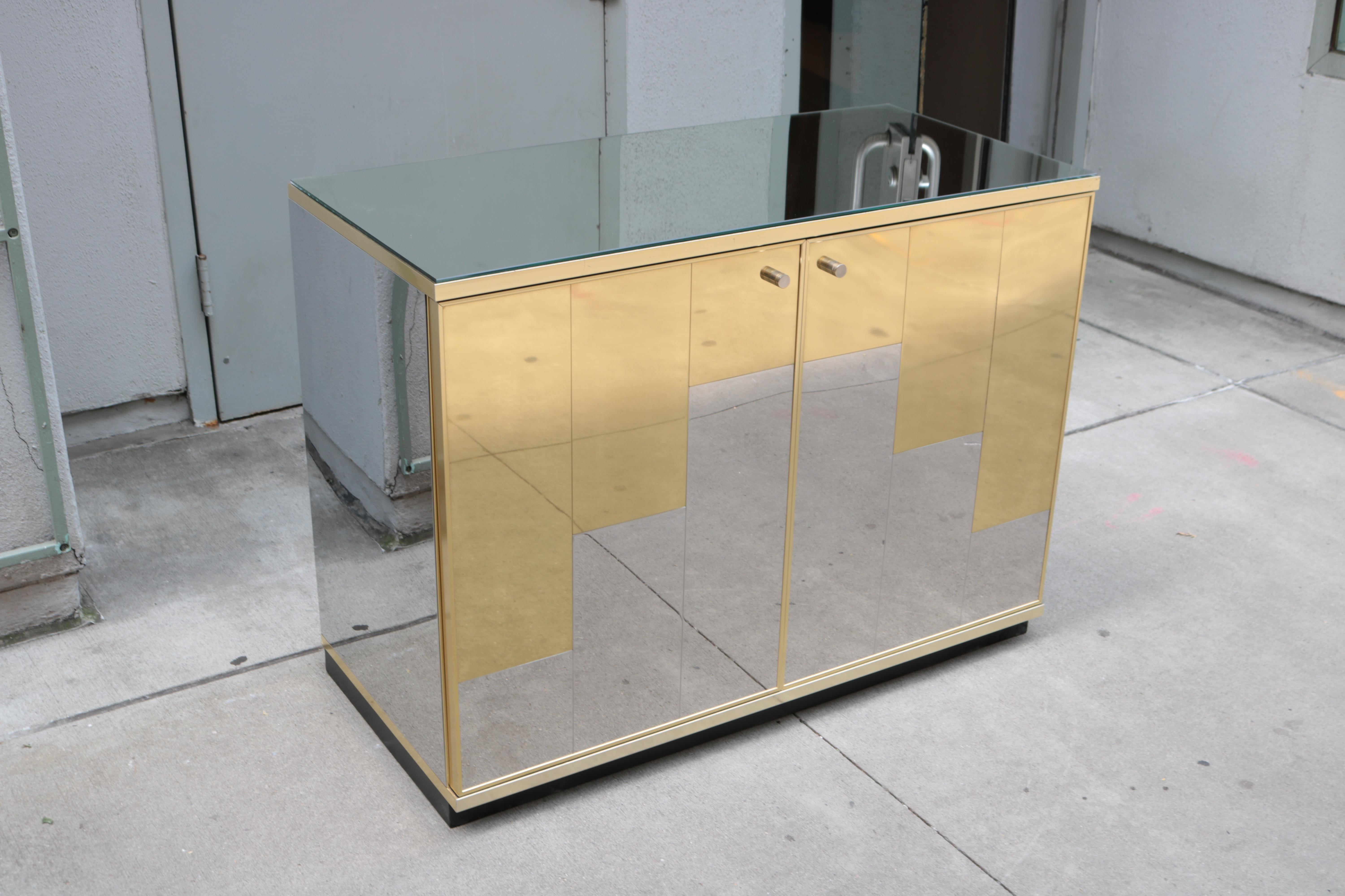 A pair of Italian Modernist cabinets. 
Mirrored glass tops,brass and mirrored metal sides,brass pulls.