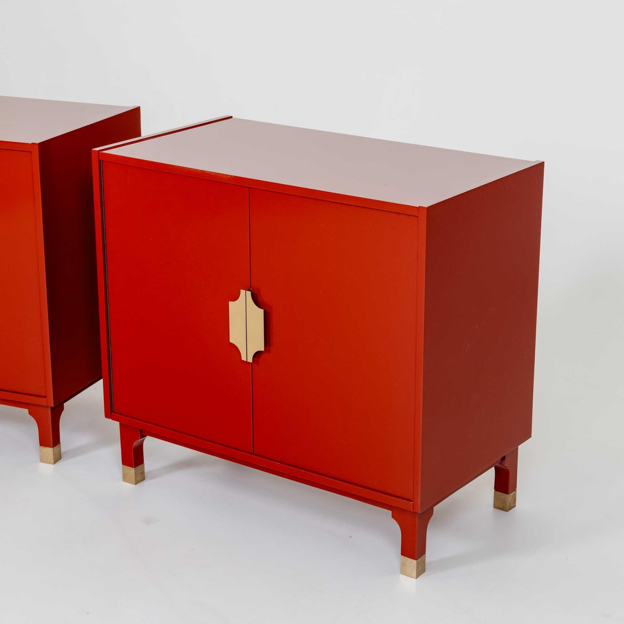A pair of Italian Modernist two door Cabinets. 
Red painted wood with patinated brass pulls.
