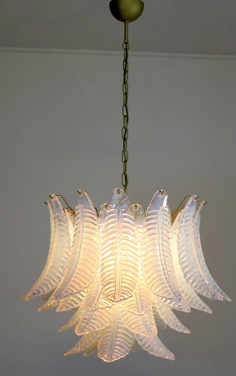 This exceptional chandelier consists of 36 felci leaves. The glass has an iridescent pearl-like quality with ripples which changes the opacity of the glass creating warm color tones.
It is newly rewired for US standards. The hanging height can be