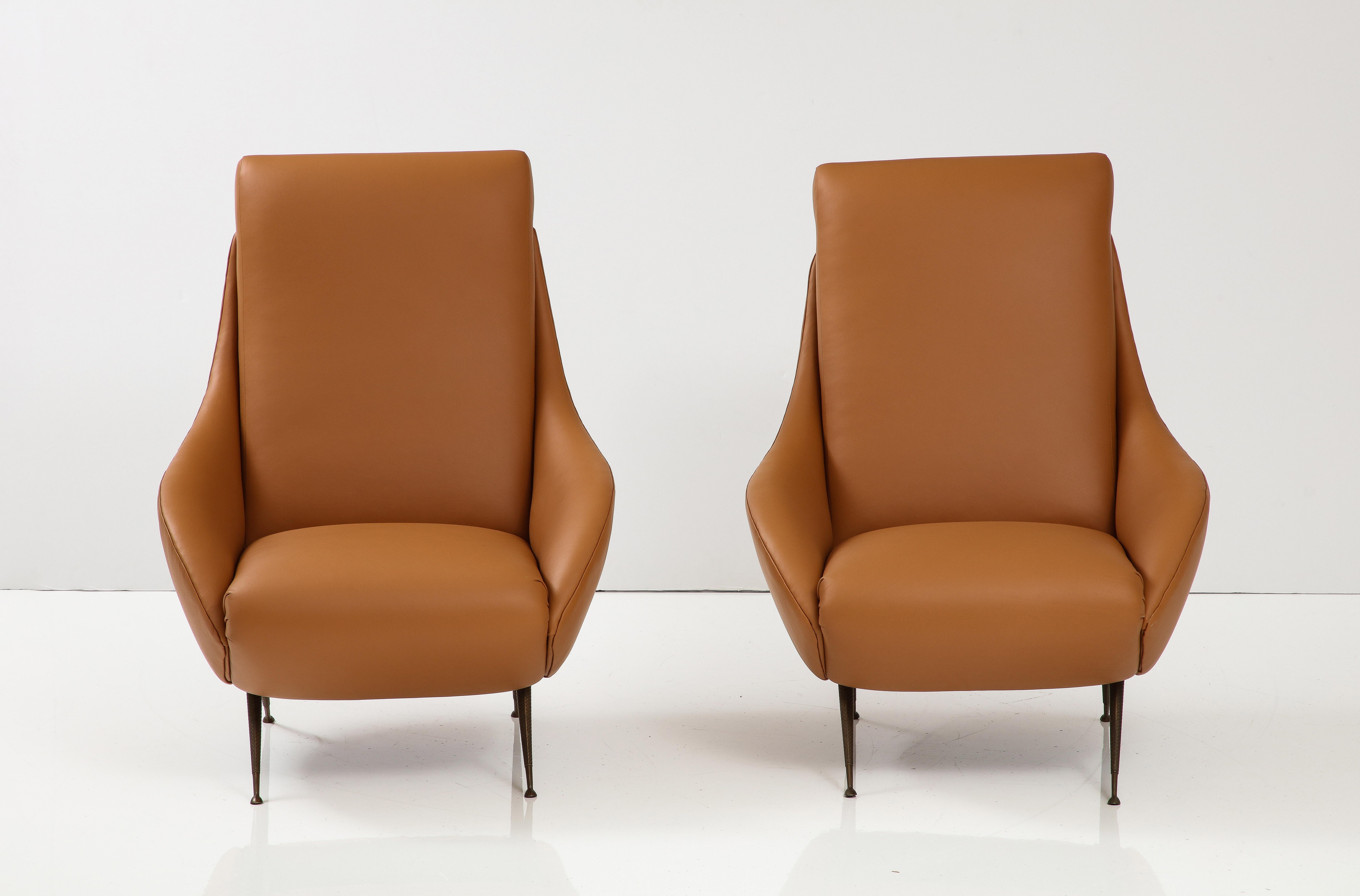 A pair of Italian modernist lounge or slipper chairs; highly sculptural in form, with metal cross-hatch motif tapered legs.  Newly re-upholstered in our professional studio with Italian camel-colored leather.  
Italy, circa 1950 
Size: 37