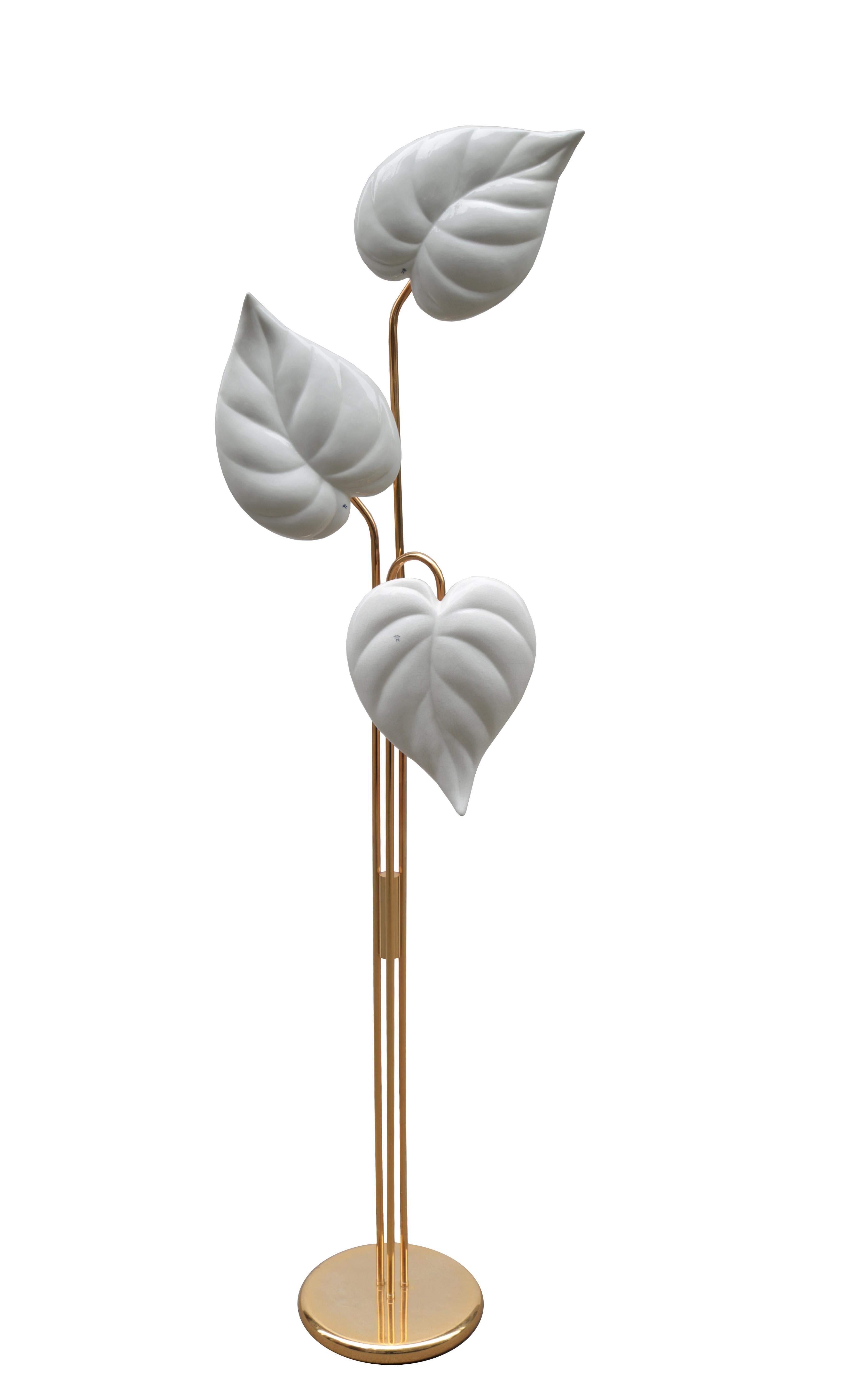 A pair of Italian modernist three-light floor lamps.
Patinated brass with stylized ceramic leaf diffusers.
  