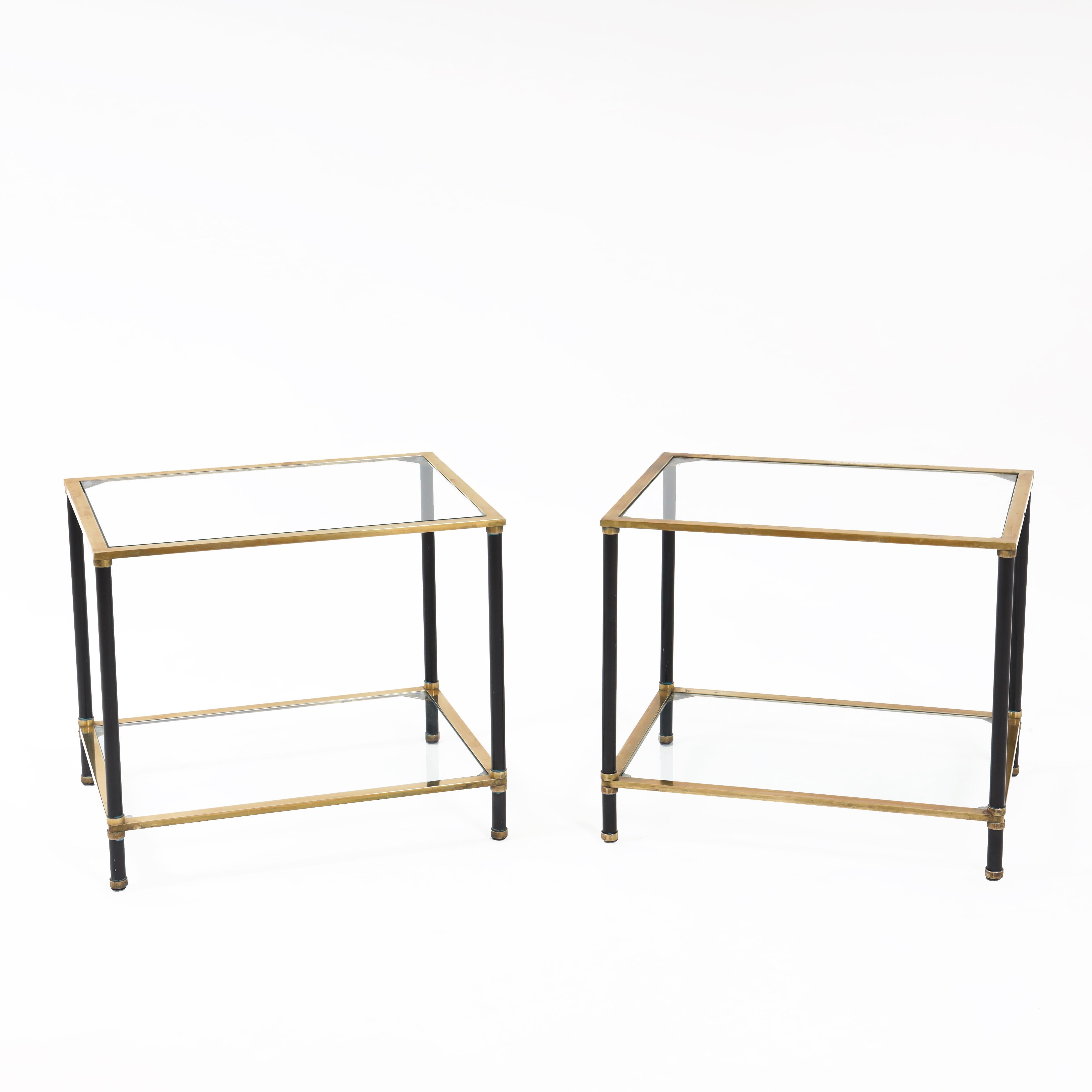 A pair of Italian modernist two tier side tables. 
Brass with ebonized leg details and glass.