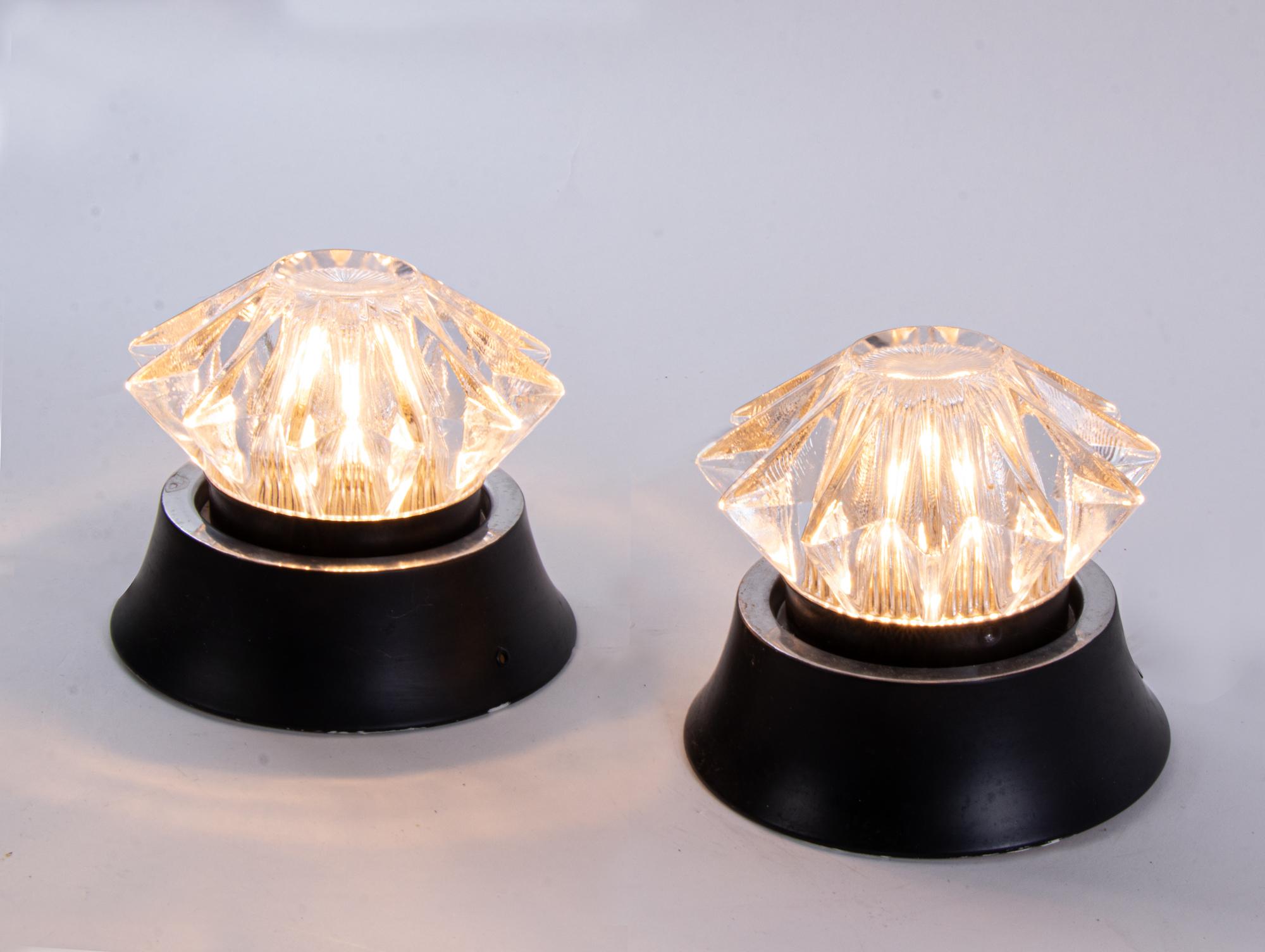 Elegant pair of modernist star-shaped glass and aluminium wall lights manufactured in Italy in the 1960s. 

Style: mid century modern, space age. 
Colors: clear and black. 
Materials: glass and aluminium. 
Measures: h 5.5