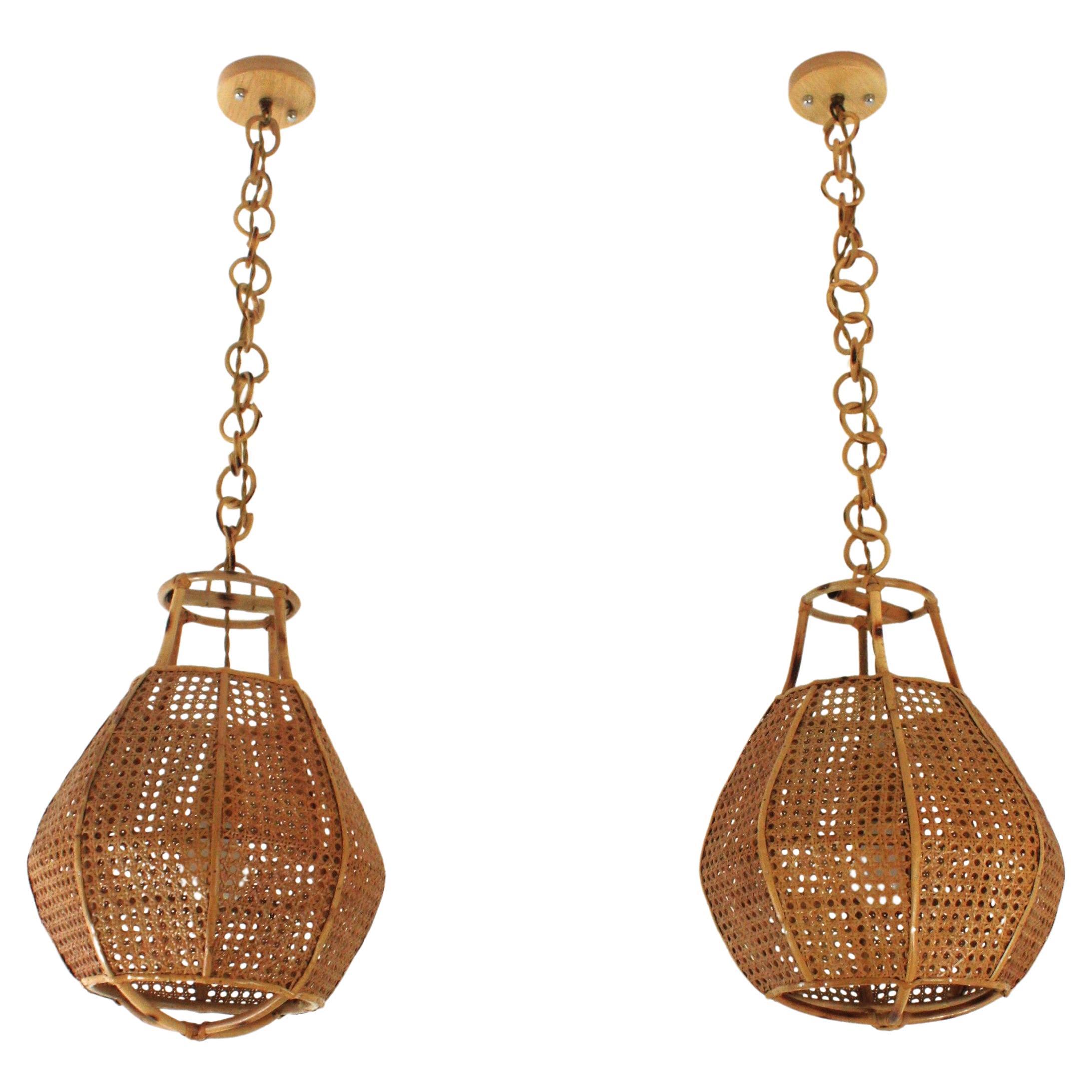Paar Mid-Century Modern geflochtene Weide und Rattan Globus förmige Laterne oder hängende Deckenleuchte. Italien, 1950er-1960er Jahre.
Die geflochtenen, kugelförmigen Schirme dieser Lampen werden durch Rattan-Details akzentuiert. Sie hängen an einer