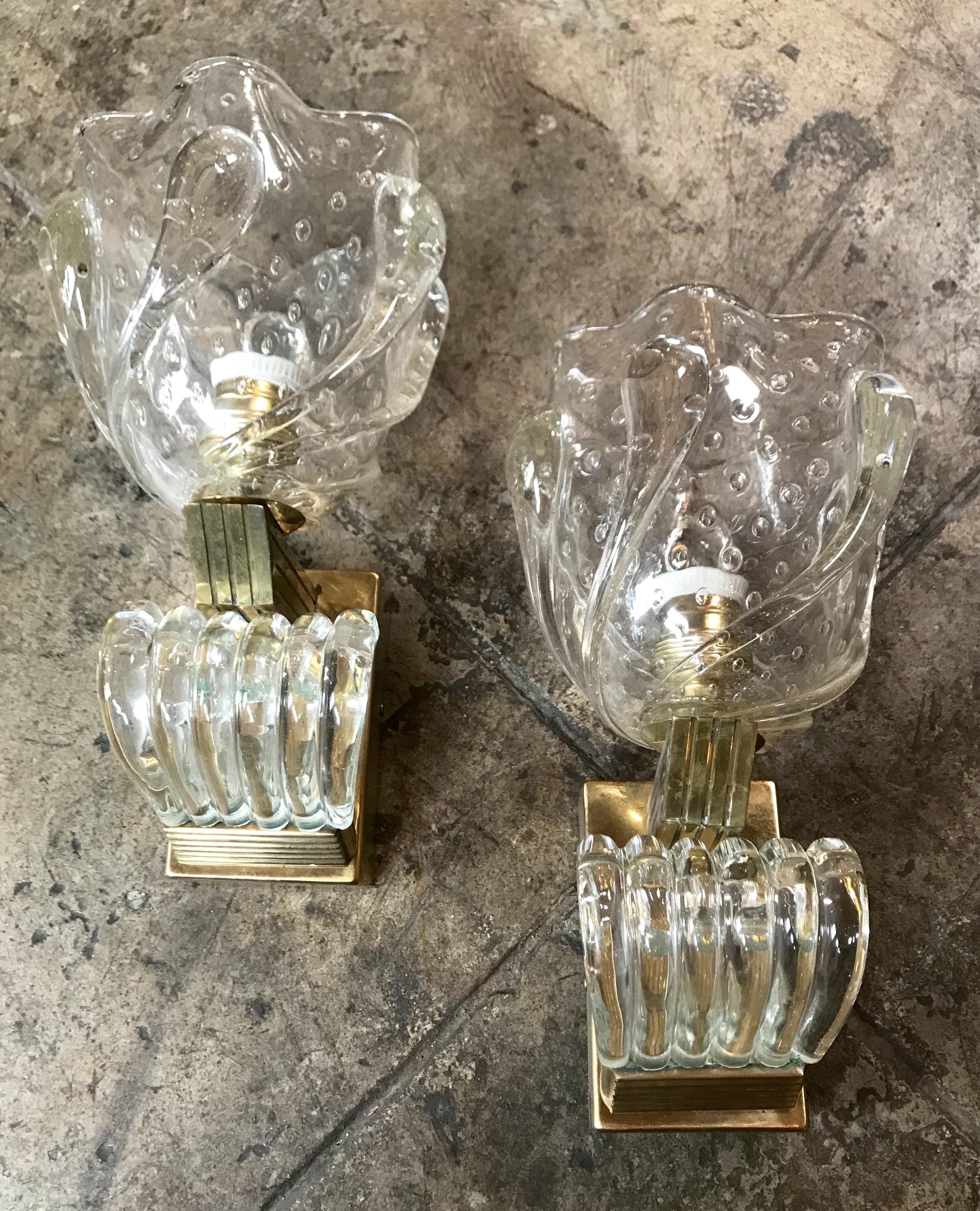 Pair of Italian Murano Art Deco Wall Lights by Ercole Barovier, 1930s.
Rare large and impressive flower-shaped sconces in heavy transparent glass featuring deep ribbing and pronounced lobes with sculptural brass-plated metal. Italy, circa 1930.