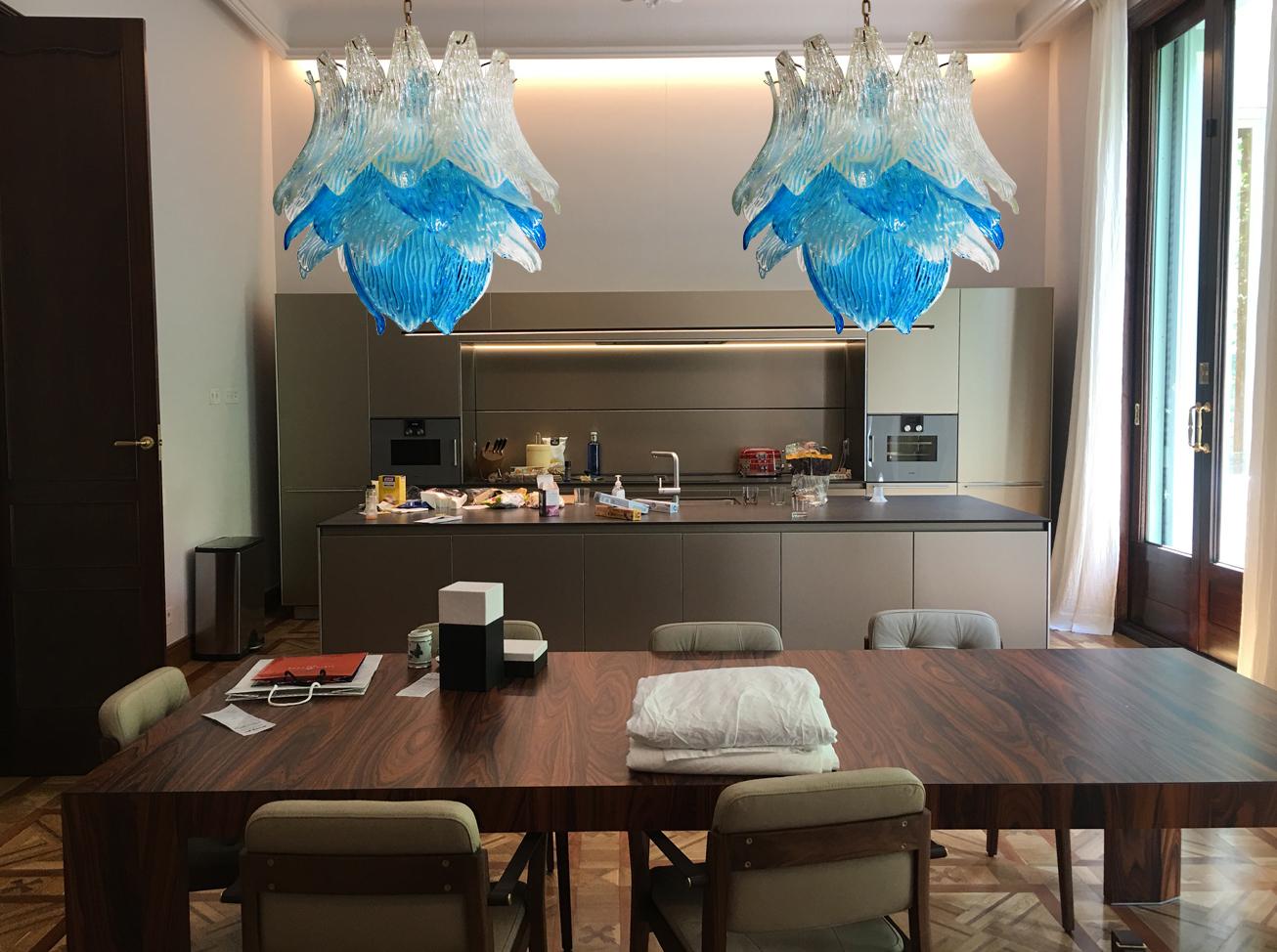 Beautiful and huge Italian Murano chandelier composed of 38 splendid transparent and blue glasses that give a very elegant look. The glasses of this chandelier are real works of art. This chandelier is shaped like a blossoming flower. Period: 1980s.