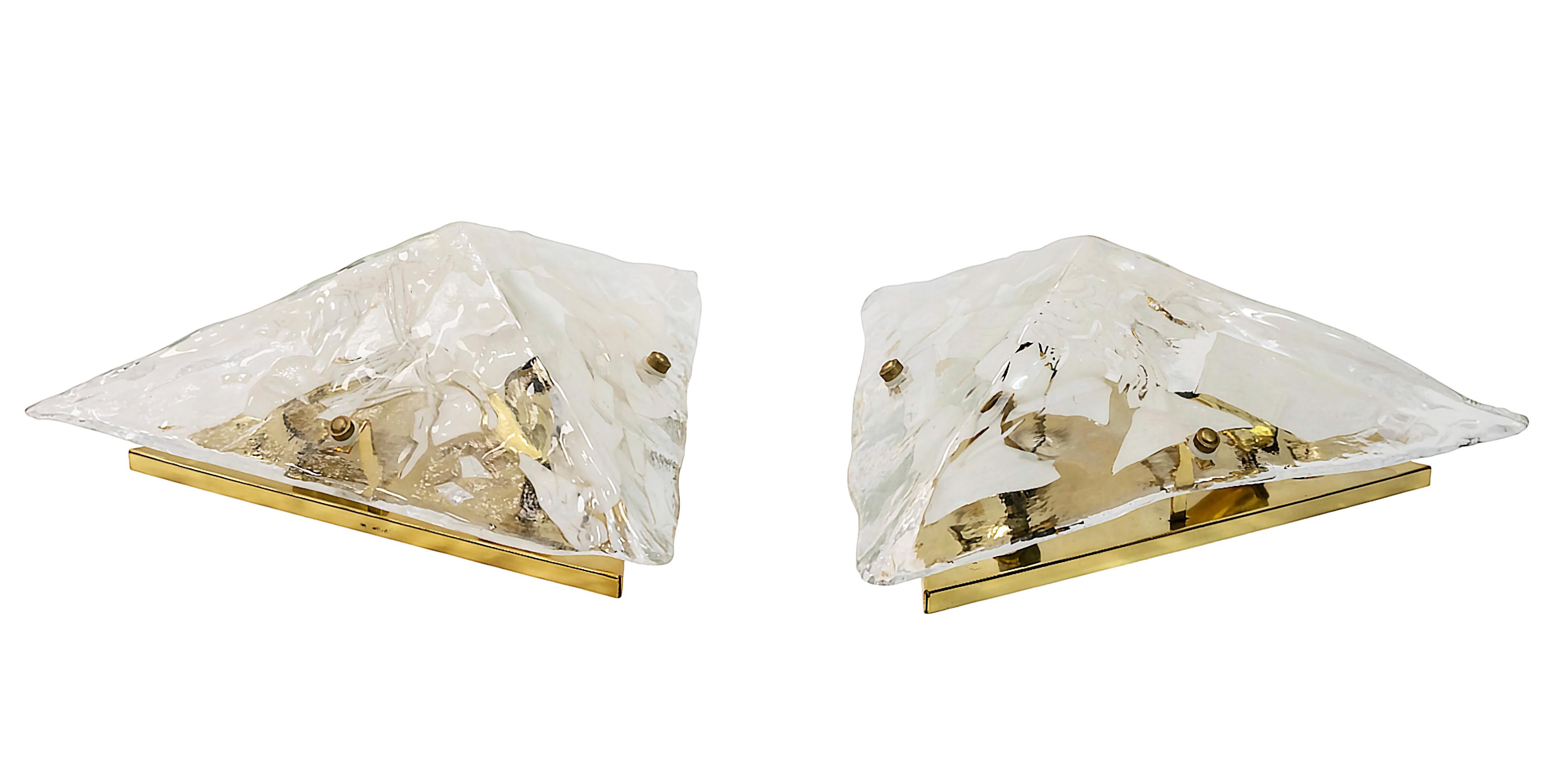 Coppia di applique o lampade da incasso in vetro di Murano a forma di triangolo realizzate a mano e base in ottone. Il vetro di Murano è di colore bianco/chiaro. 
Ogni applique è dotata di 3 prese per lampadine di tipo E14 (le lampadine non sono