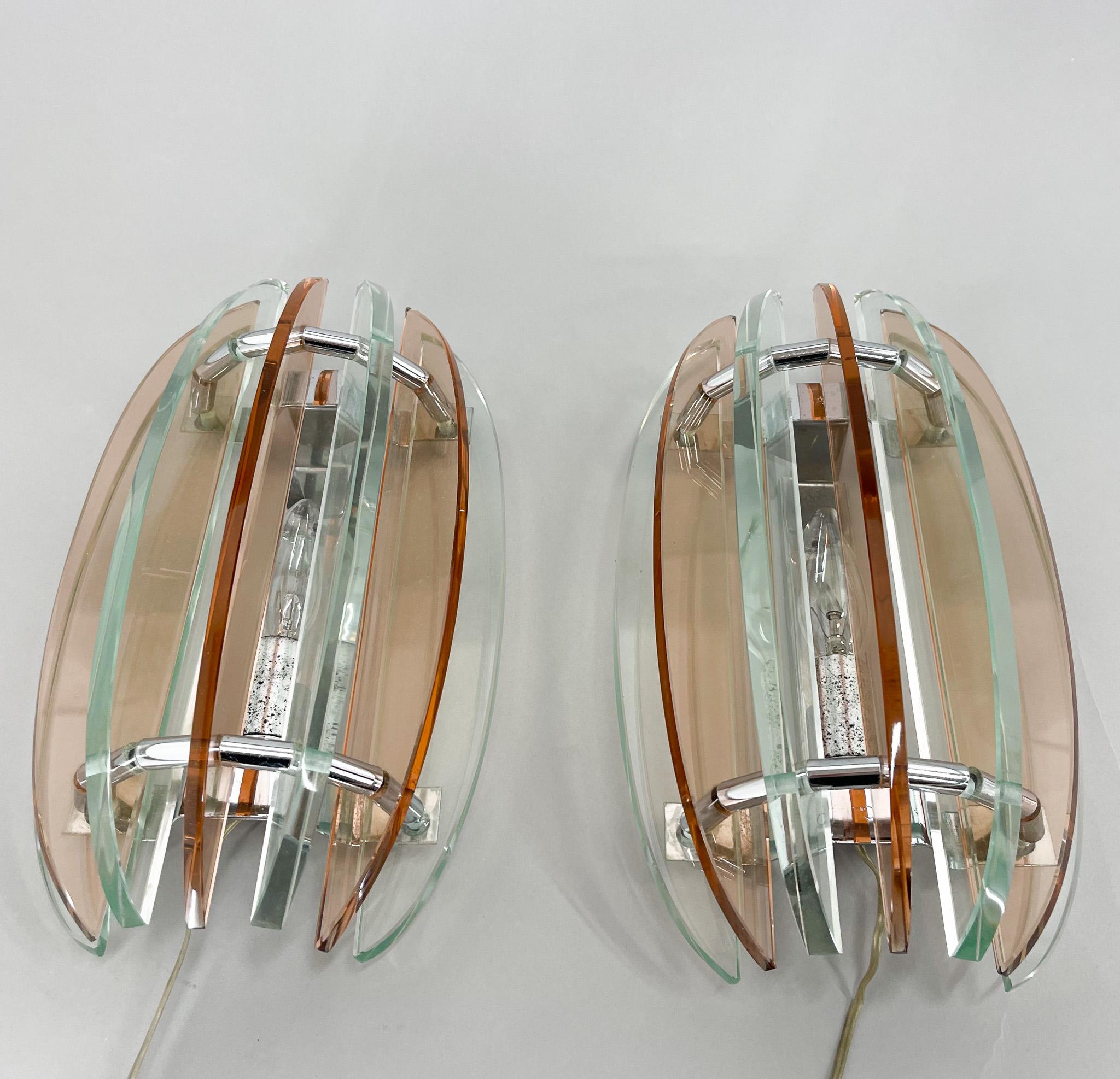 Ensemble de deux jolies lampes murales par VECA Italie. Fabriqué en verre de Murano dans des couleurs pastel et en chrome. Labellisé par le fabricant. 
Ampoules : 2 x E12-14.