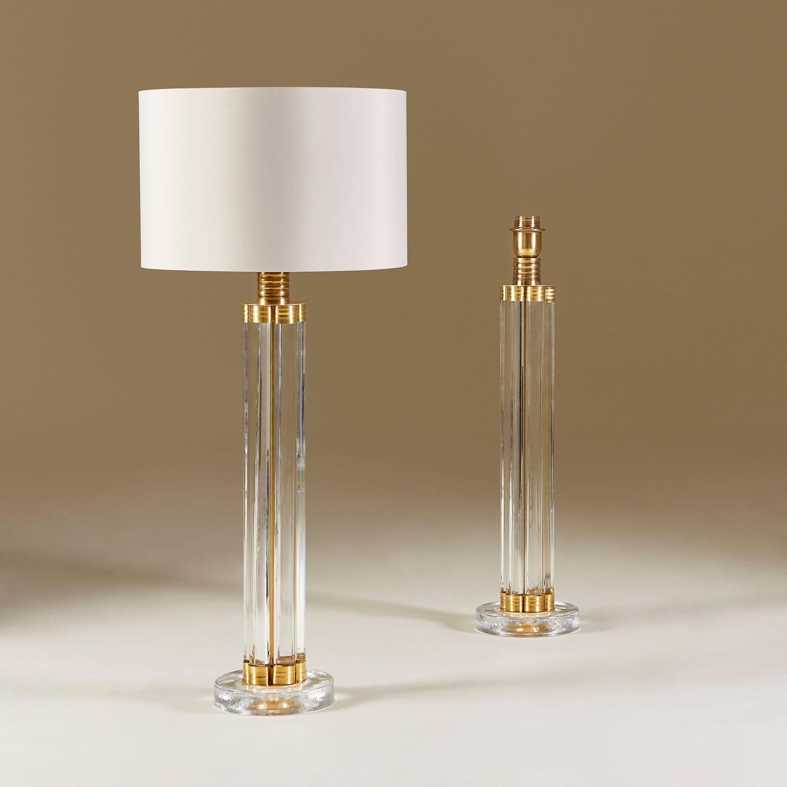 Striking contemporary pair of table lamps each made of six vertical glass rods held together at the top and bottom with decorative brass elements, standing on heavy square glass bases with rounded edges.