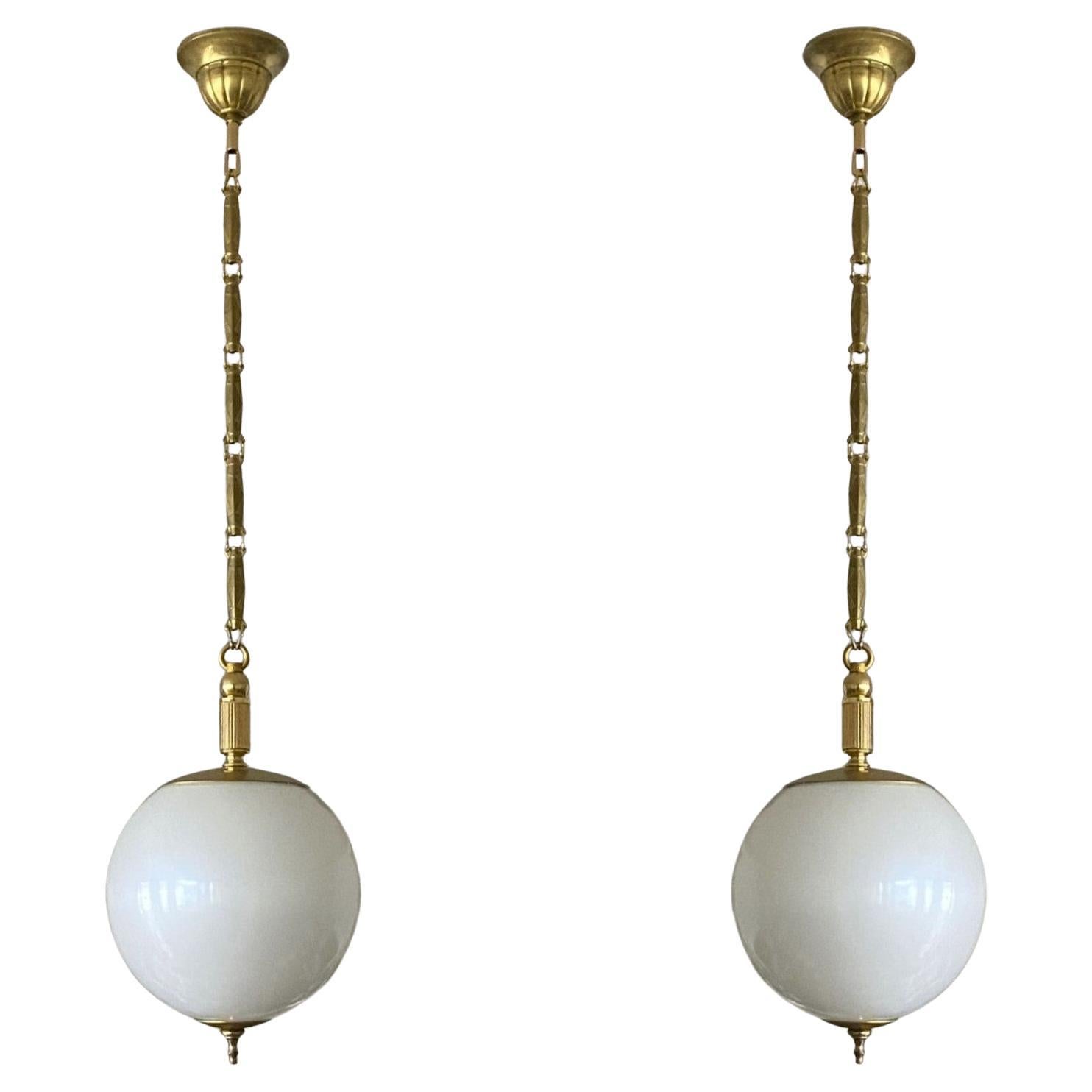Ravissante paire de pendentifs globe en verre de Murano en optique perle, montures en laiton, chaîne et baldaquin, Italie, années 1960. Ces pendentifs magnifiques et rares ressemblent vraiment à une grosse perle suspendue au plafond. Avec une seule