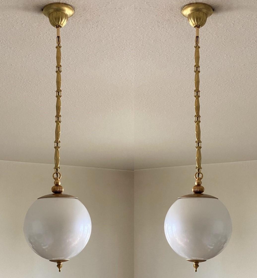 An elegant pair of Murano glass globe pendants in pearl optic, brass mounts, chain and canopy, Italy, 1960s. These beautiful and rare pendants look really like a big pearl hanging from the ceiling. With a single porcelain Edison E27 light socket for