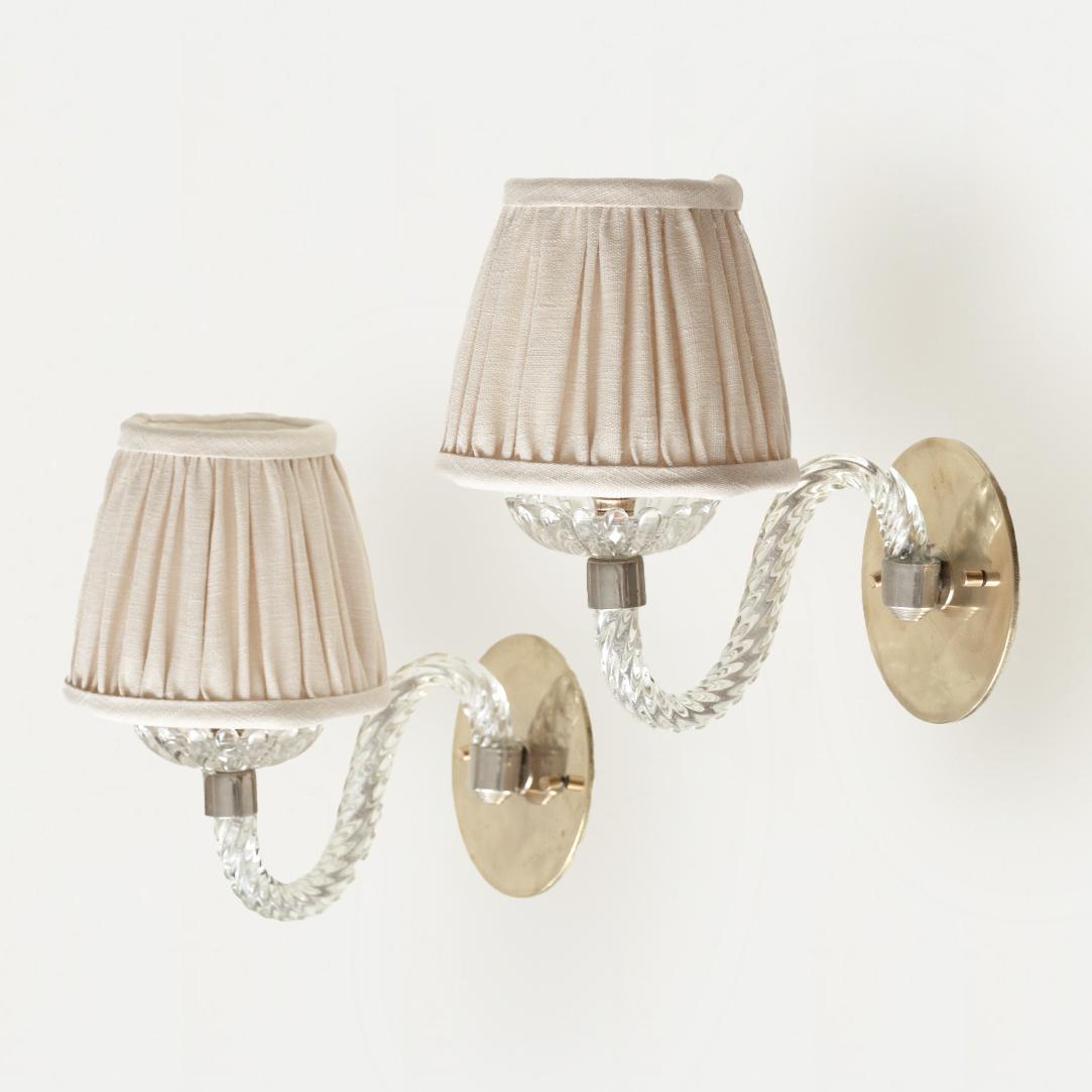 Beautiful pair of Italian Murano glass sconces. Clear textured curved glass arms with scalloped glass disc and single socket. Nickel detailing and newly added brass backplate. Newly re-wired and new linen shades.