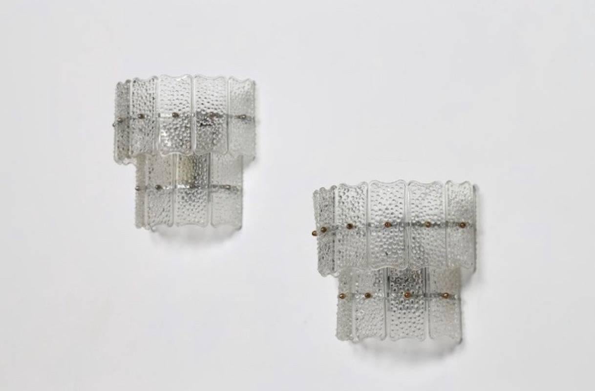 Pair of Italian Murano glass and metal wall lamps from circa 1960s. As shown on the photos, please note that the two lamps are slightly different - one has silver colored details and other has them in brass color.