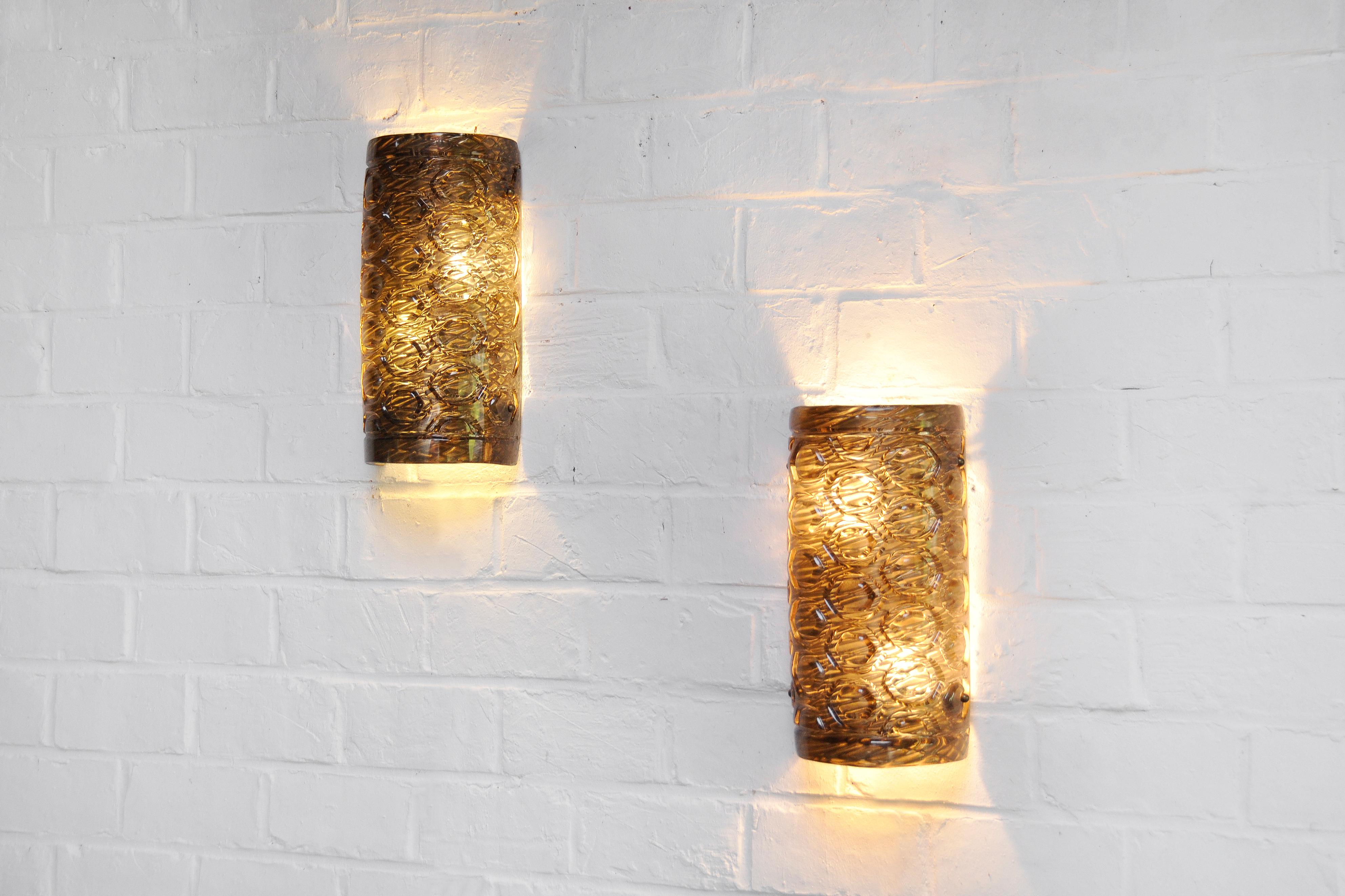 An impressive pair of Italian murano wall lights made in the 60's. These lamps are constructed out of two layers. First a gilded shell with a fibre like structure. This first layer is covered in geometrical patterned murano glass. This unusual