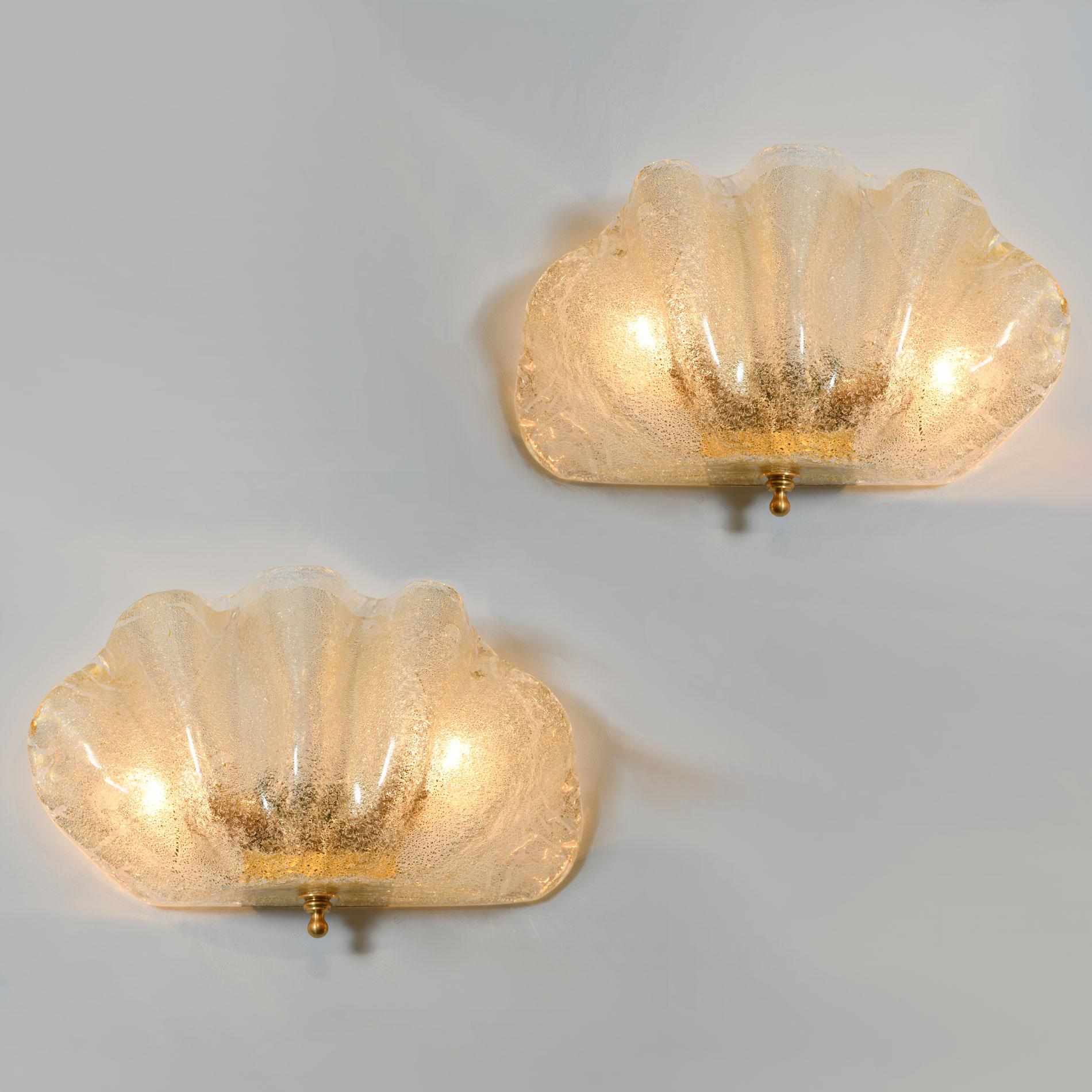 Contemporary textured subtle gold and clear Murano glass 'clam shell' wall lights with gold fitting and decorative finial detailing. Exudes warm golden glow.