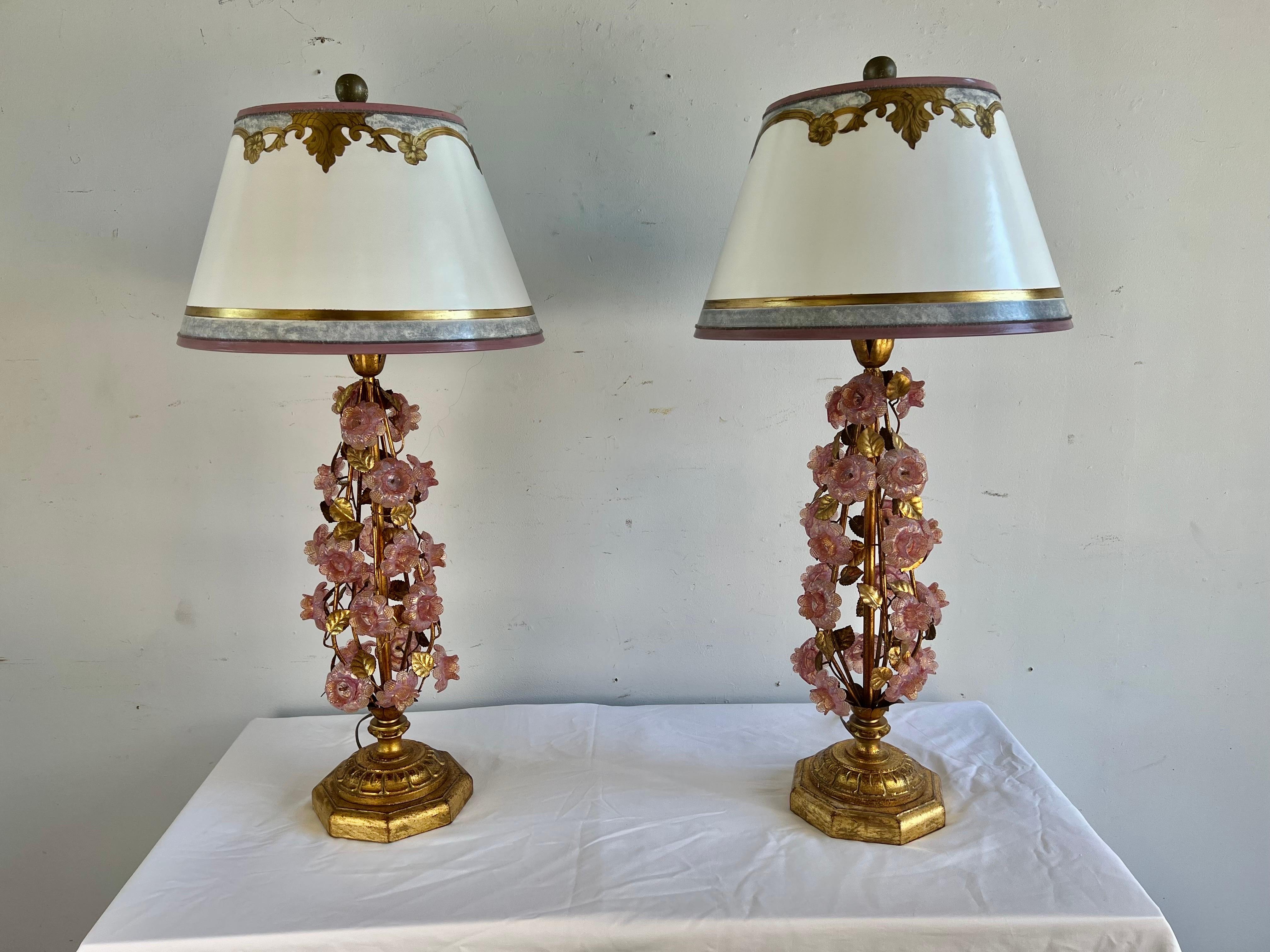 Pair of custom Murano Glass Lamps with pink hand blown flowers throughout. The lamps stands on octagonal shaped giltwood bases. The lamps are crowned with hand painted parchments shades. The lamps are wired and in working condition.