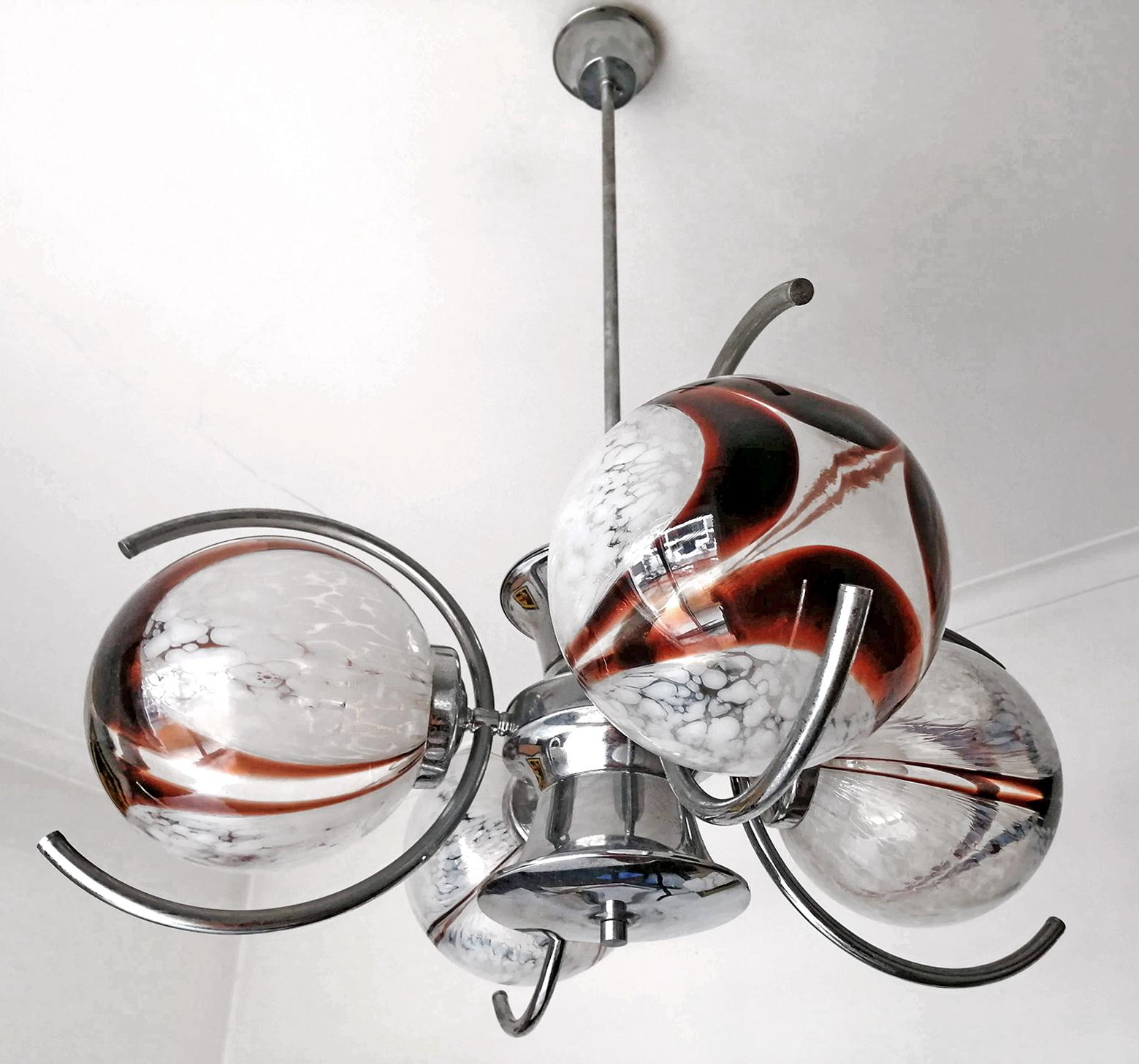 Unusual vintage 1960s Italian modernist Murano blown art glass globes chrome chandelier
Measures: Globe/diameter 8 in. (20 cm).

Measures:
Diameter 26 in / 66 cm
Height 35.4 in / 90 cm
Weight 16 lb/ 7 Kg
Four light bulbs E27/ good working