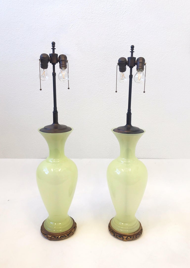 Glamorous 1970’s Italian light green Murano Opaline glass lamps and bronze with original off white silk shades. 
They show minor wear consistent with age(see detail photos). 
They take two regular 75w max Edison lightbulb.
Newly rewired.