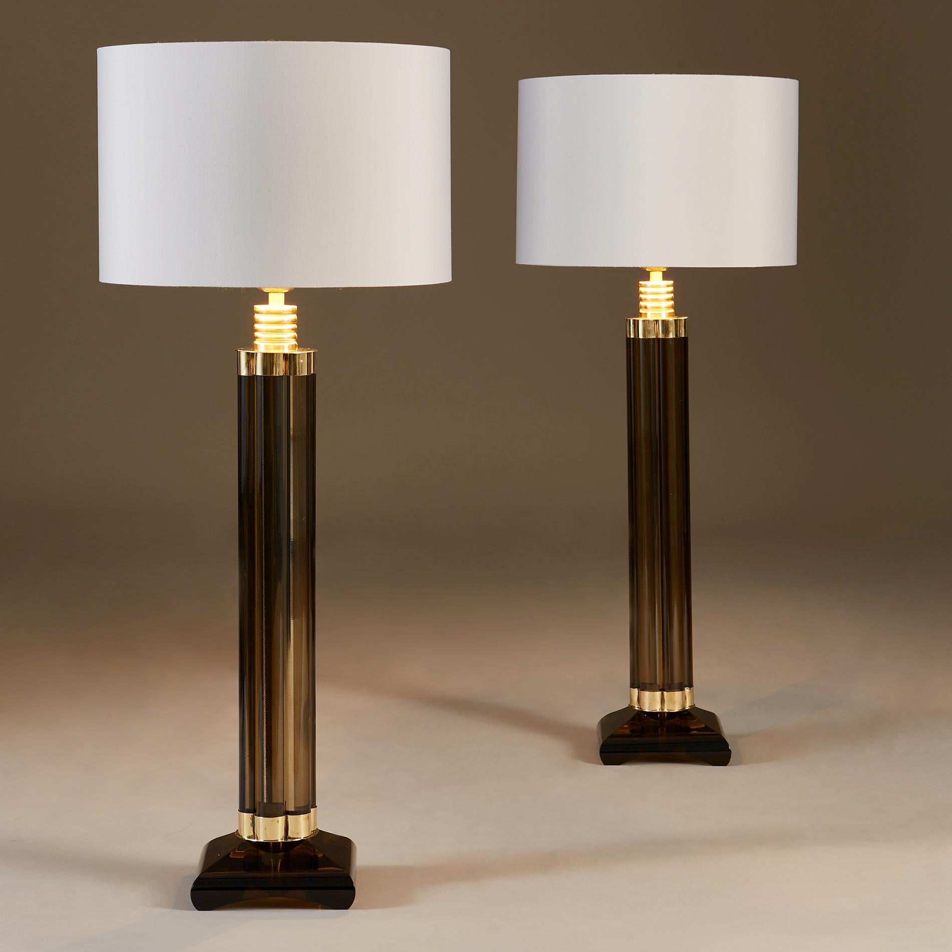 Striking pair of smokey Murano glass table lamps each made of six vertical glass rods held together at the top and bottom with decorative brass elements, standing on heavy square glass bases with rounded edges.
Height listed is without shades.

Also