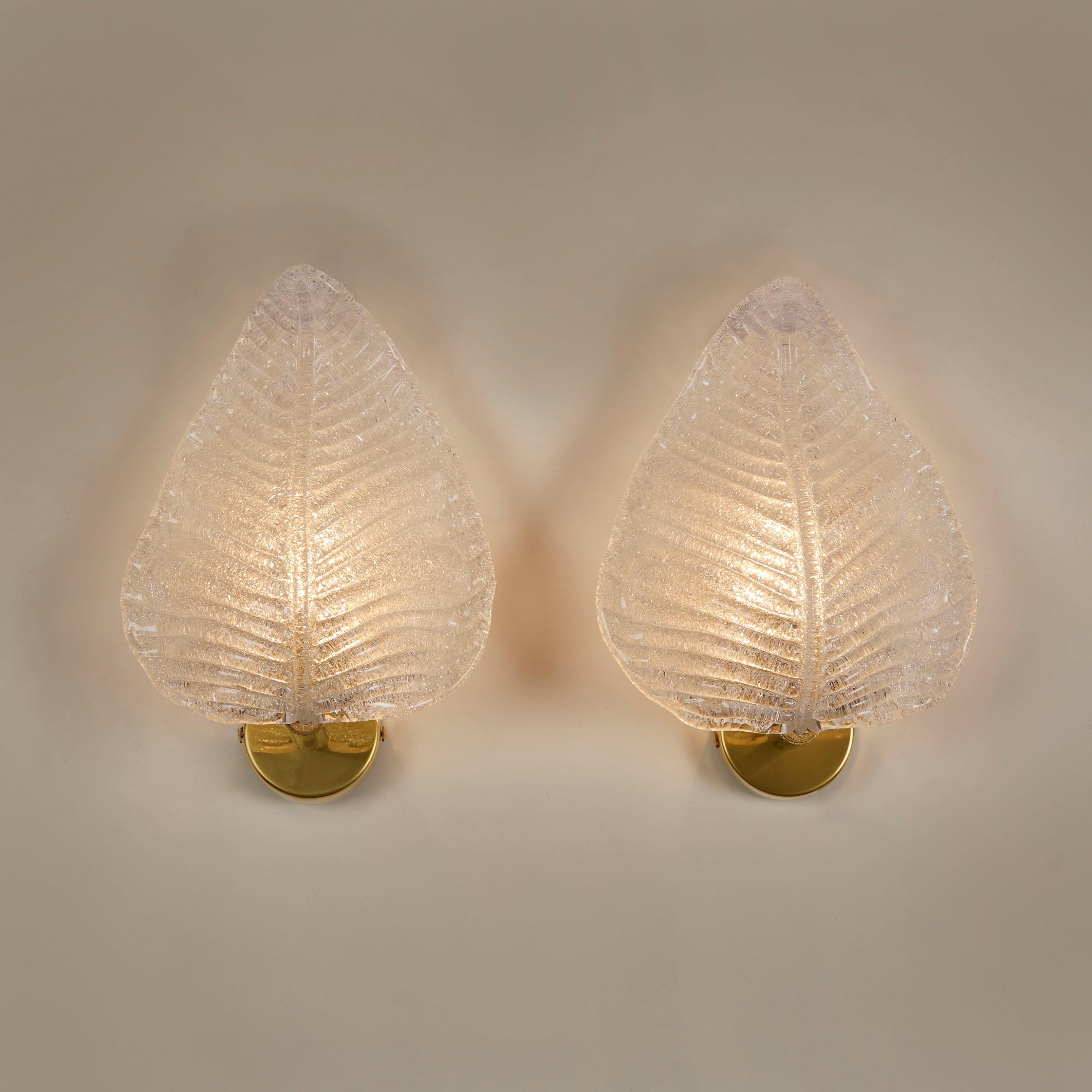 Dickes mattiertes Murano-Glas, das zu einem Blatt geformt und strukturiert wurde. Sitzt auf einer runden Wandhalterung aus Messing. Goldflecken sorgen für einen warmen Glanz.