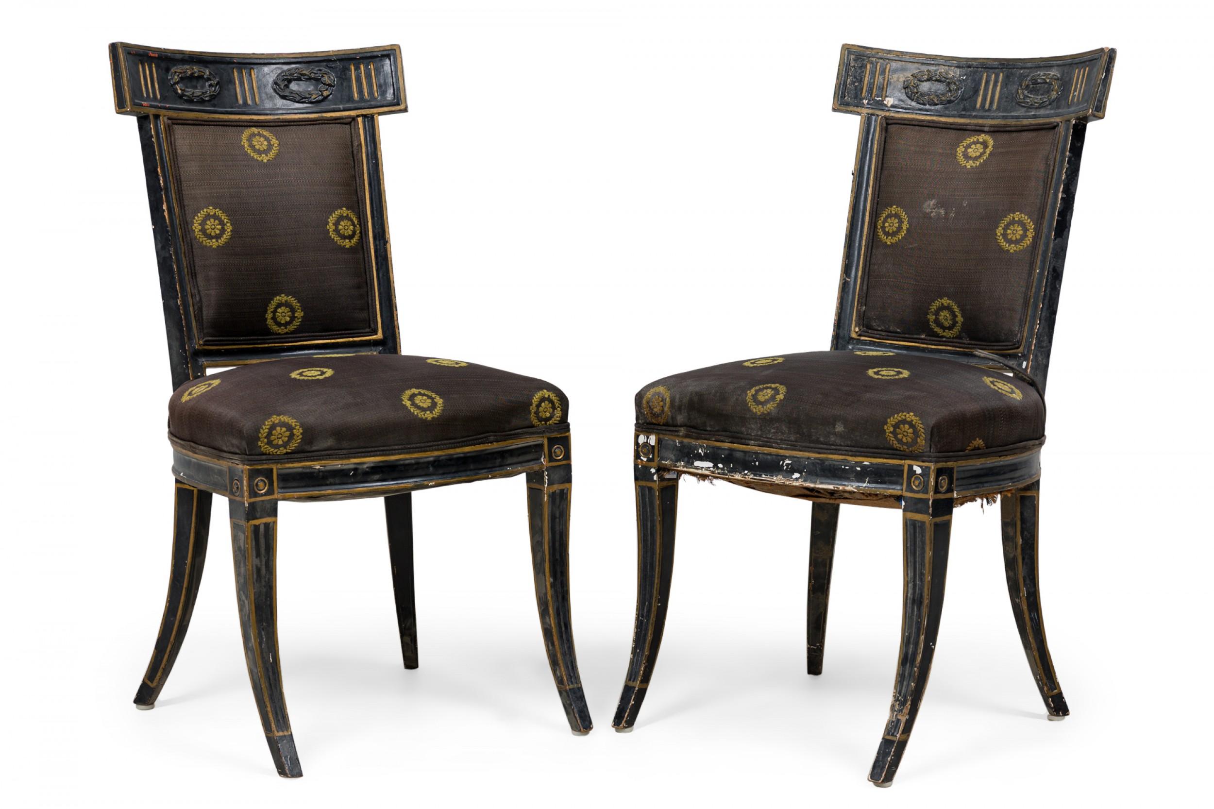 Pair of Italian Neo-Classic (18th Century) black painted side chairs with curved backs and rectangular tops carved in a two-wreathed swag reserve, trimmed and highlighted in gold, the back and seat upholstered in black fabric interspersed with