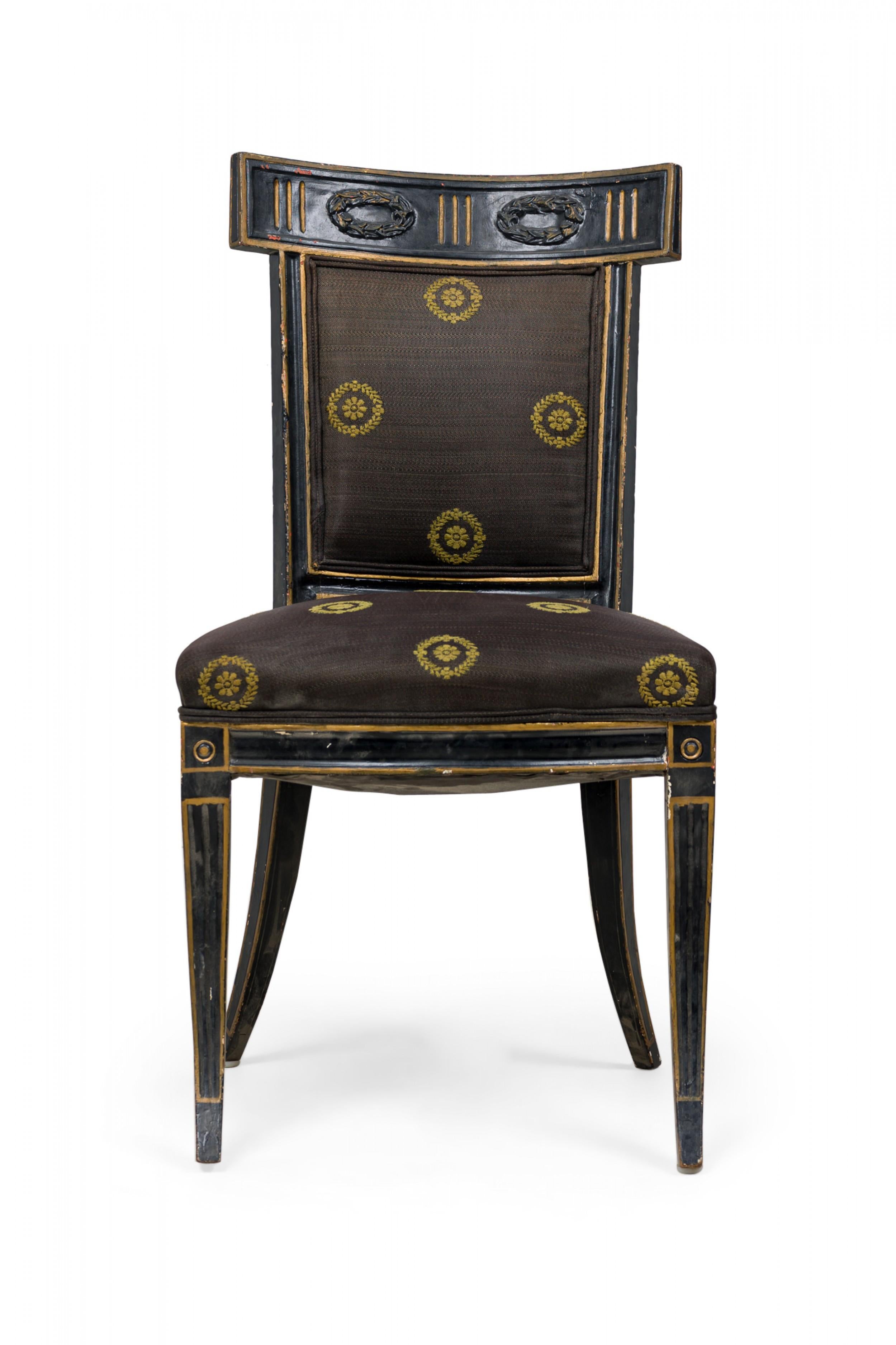 Paire de chaises d'appoint italiennes néoclassiques (XVIIIe siècle) peintes en noir, à dossier incurvé surmontant un plateau rectangulaire sculpté de guirlandes à deux couronnes, avec dossier et assise tapissés de tissu noir à médaillons dorés,