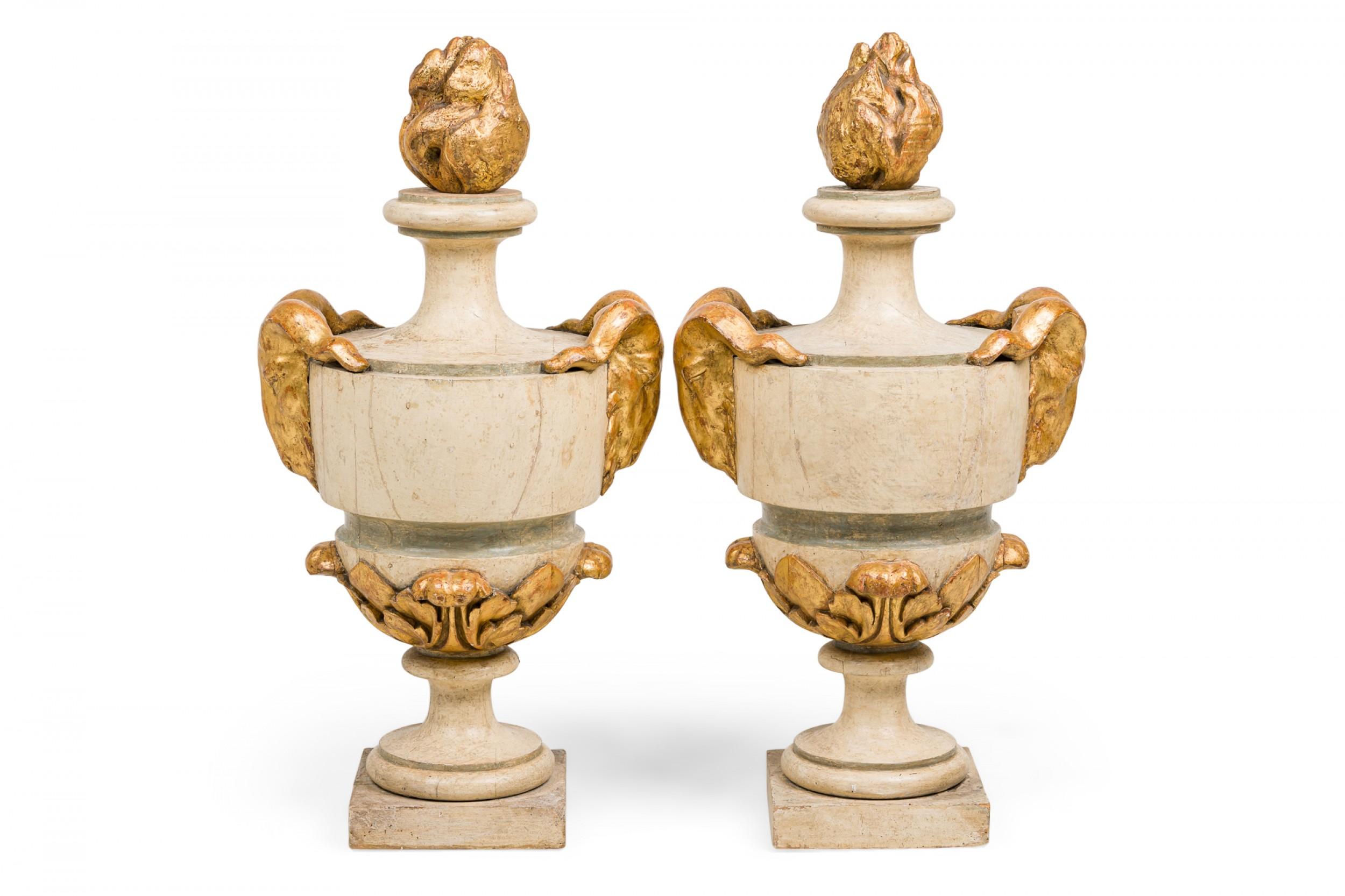 COPPIA di urne monumentali neoclassiche italiane (XVIII secolo) in legno dipinto di bianco a forma di balaustro con terminali a fiamma dorati, maniglie finte a testa d'ariete e basi quadrate con bordi a volute e fogliame (PREZZO A COPPIA)

Condit: