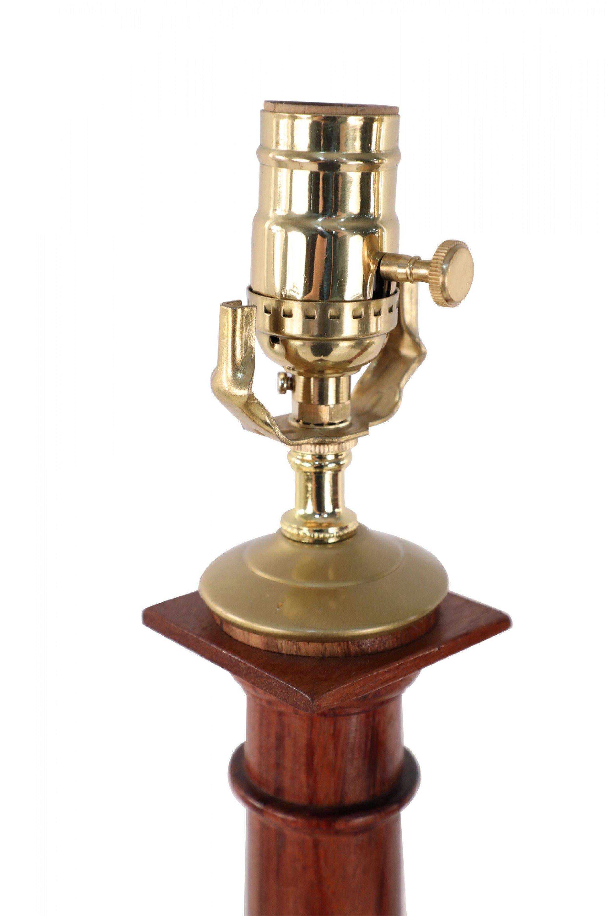 Pair of Italian Neo-classic style stained wooden table lamps with column shaped bodies on a raised square base and brass hardware (priced as pair).
