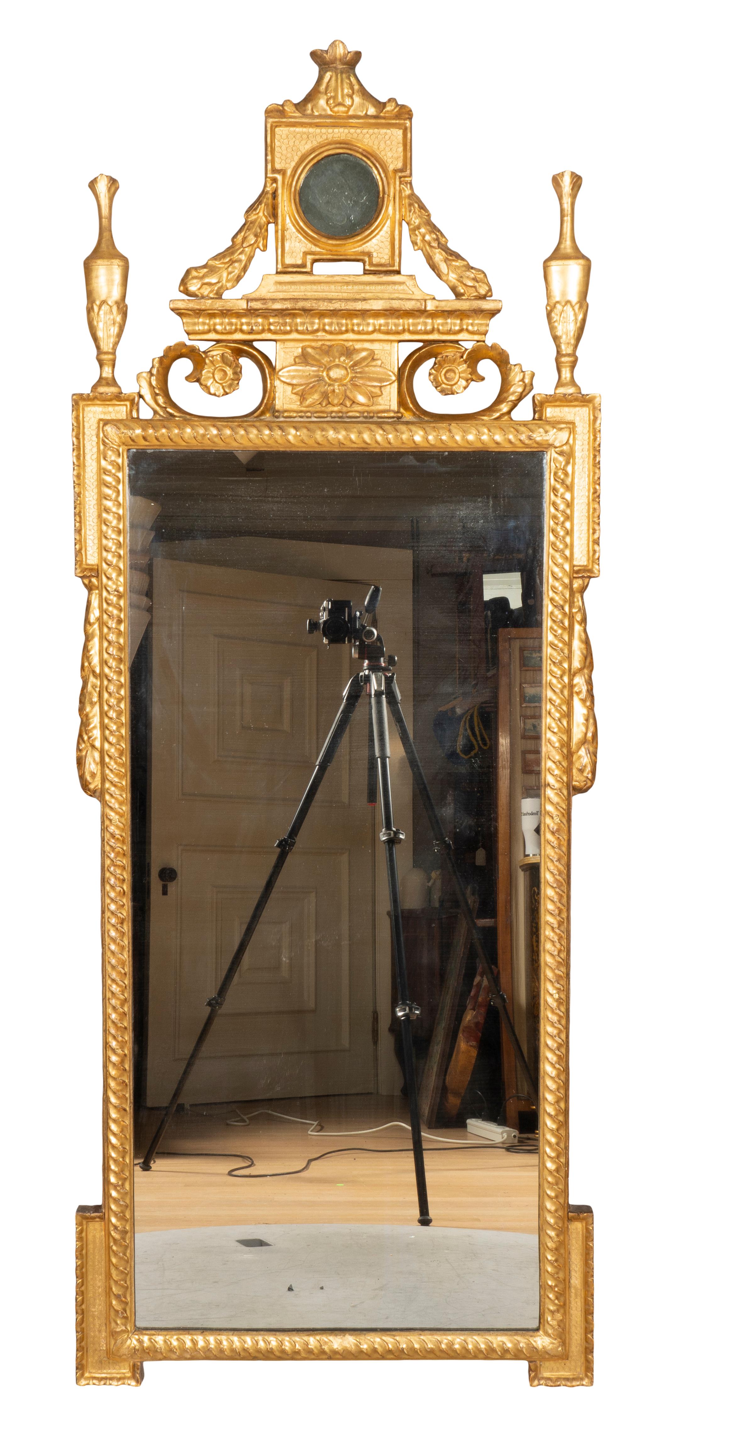 Each with panel and inset round mirror superstructure flanked by laurel swags over open scroll and rosette decoration all flanked by a pair of urns, all over a mirror plate set in guilloche carved frames with laurel swags. Beautiful original gilding