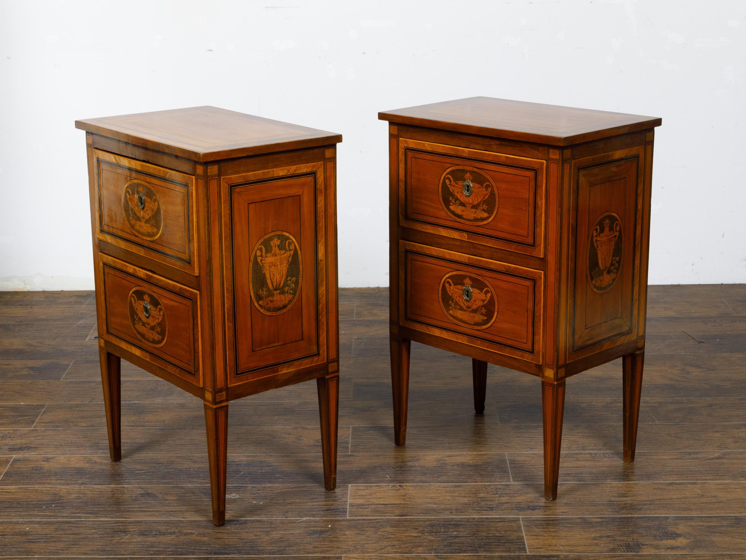 A pair of Italian Neoclassical style walnut bedside tables from circa 1800 with two drawers and marquetry décor. This pair of Neoclassical period Italian walnut bedside tables from circa 1800 showcases the unparalleled craftsmanship and elegant