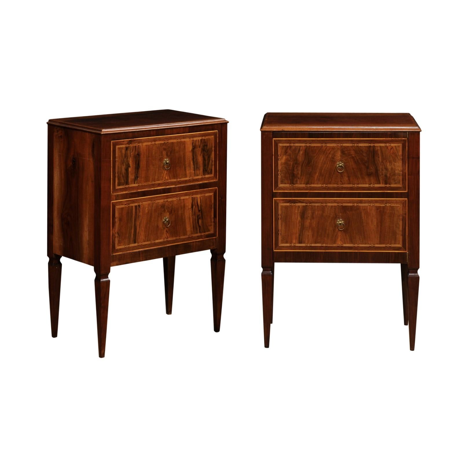 A pair of Italian Neoclassical period walnut and mahogany bedside tables from the late 18th century with two drawers each, butterfly veneer, cross banding and tapered legs. This pair of late 18th-century Italian Neoclassical period bedside tables is