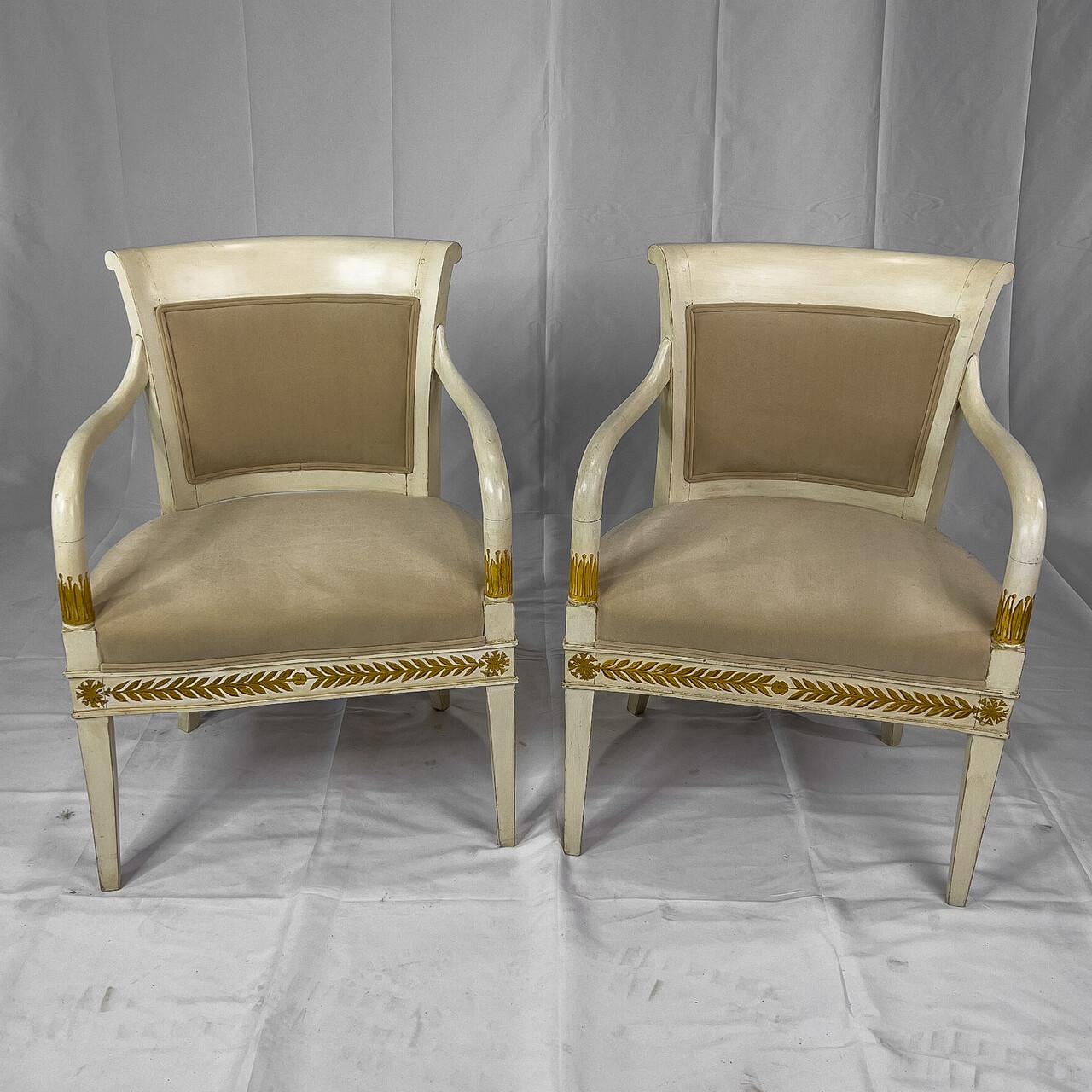 19th century painted Italian armchairs in Neoclassical style having gilt detail, a rounded back, upholstered seat and curvaceous arms.