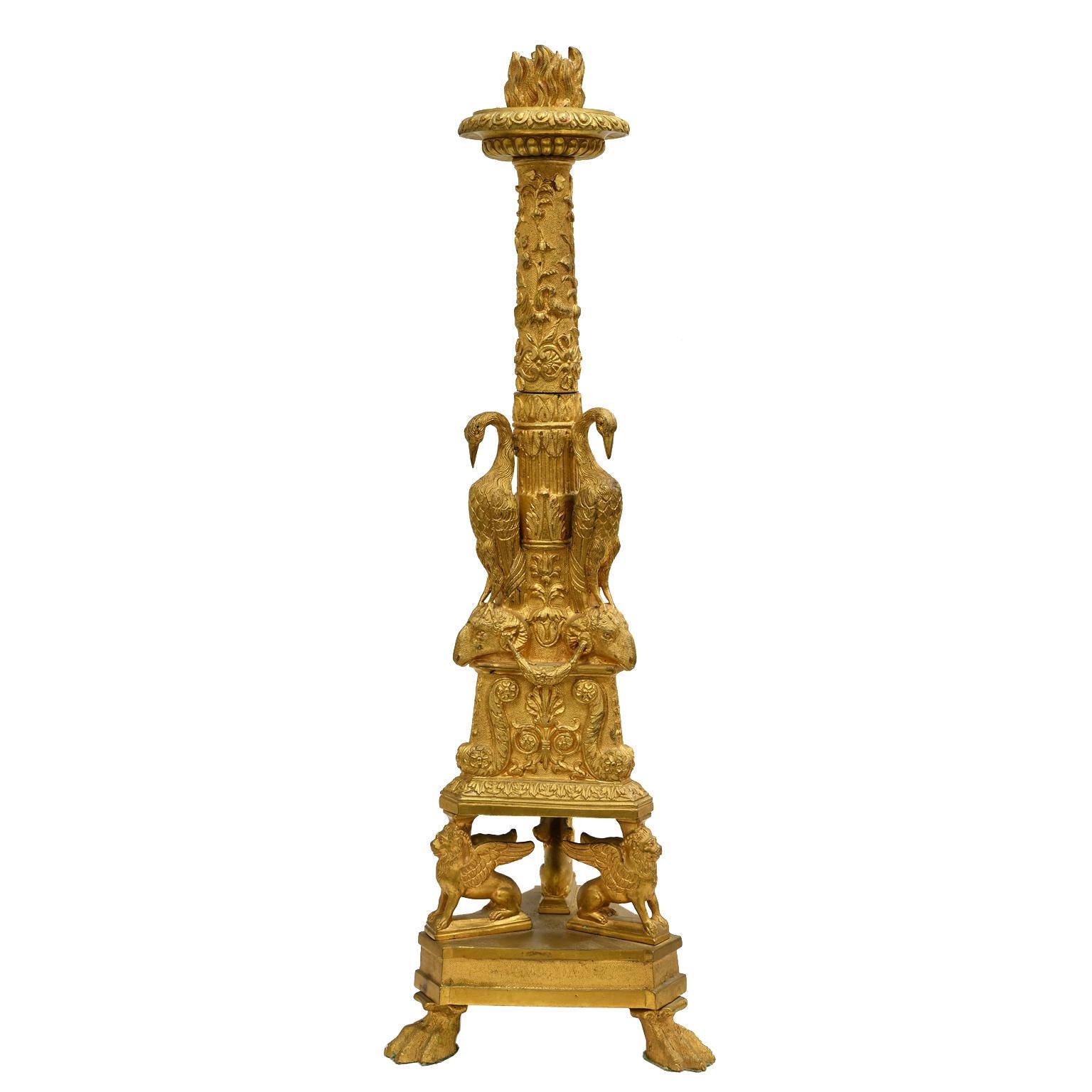 A fine pair of neoclassical architectural candlesticks in gilt bronze (bronze doré) after a design by Giovanni Battista Piranesi (Italian, 1720-1778) with flame nozzles and lobed drip pans on foliate-decorated columns resting on a triangular base