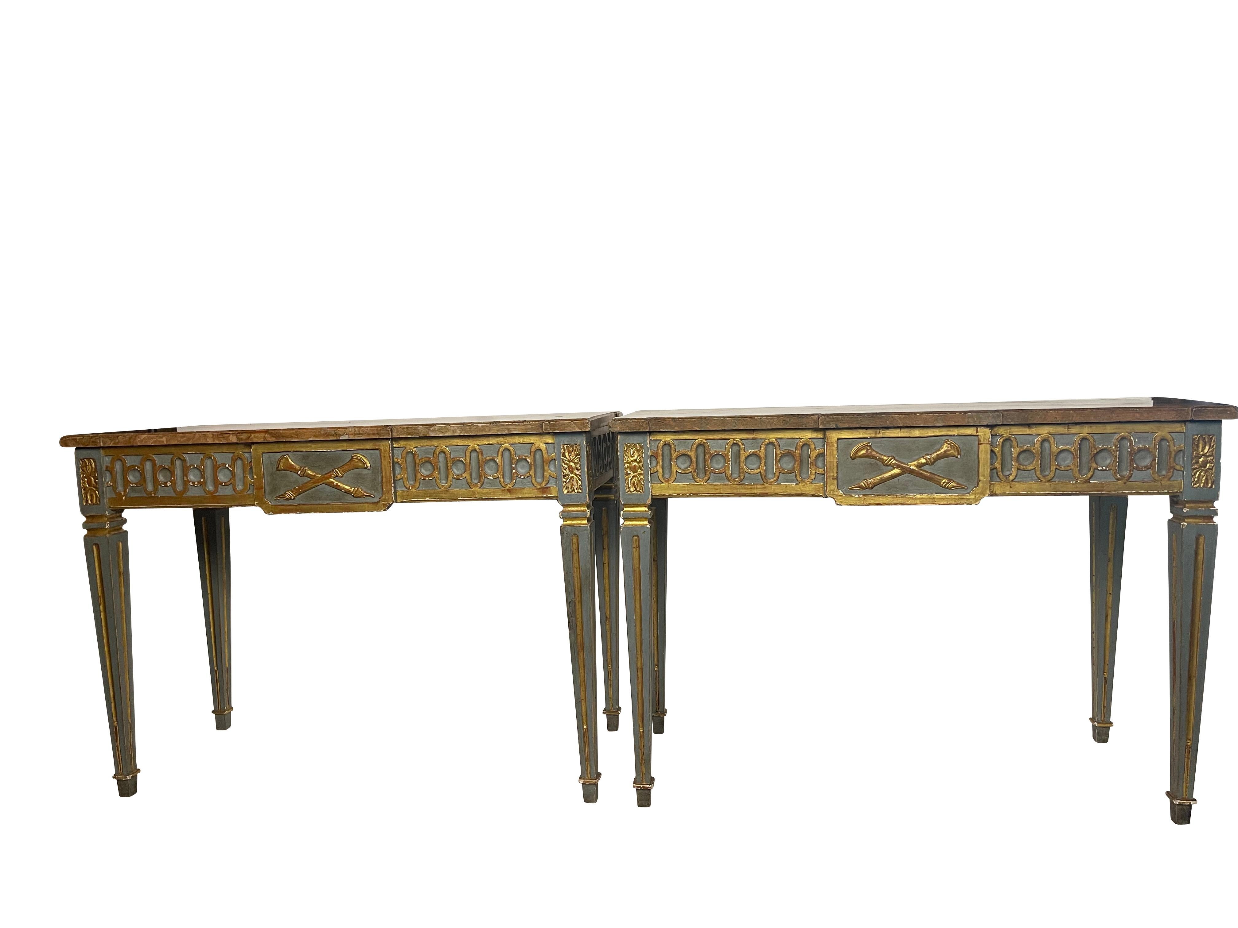 Exceptional 18th - 19th Century pair of Neoclassical gilt and painted console tables with rose marble tops. Green/ blue paint with gilt trip throughout. Reeded legs with rosette decoration on the corners. Crossed gilt hunting horn design on center