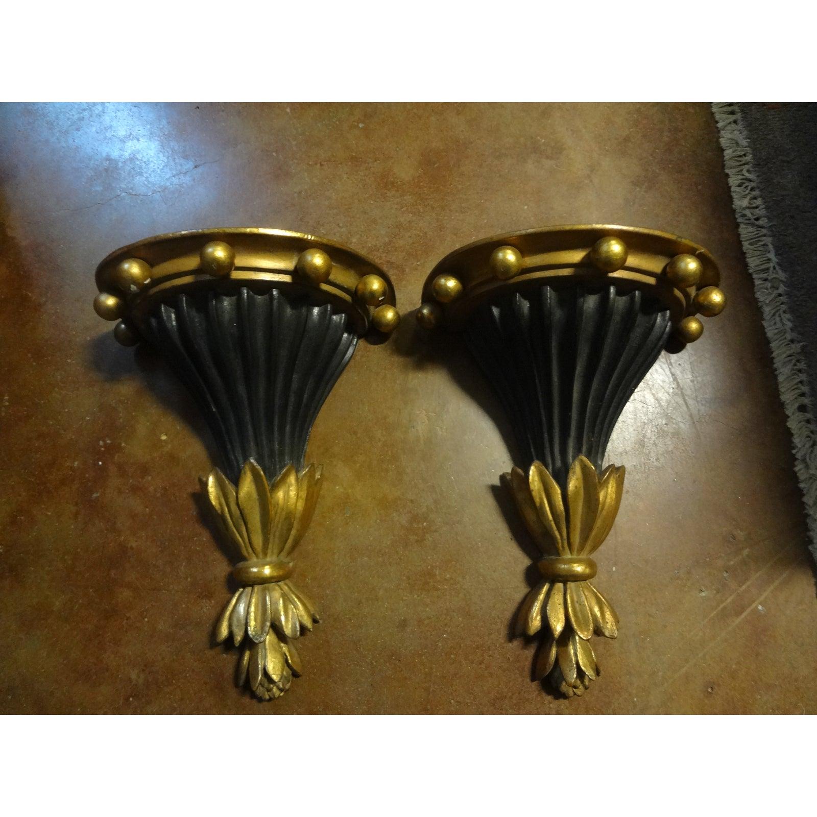 Stylish vintage pair of Italian neoclassical style black and gilt terracotta wall brackets. This beautiful pair of stylish wall brackets was most likely made by Palladio and date to the 1960s.