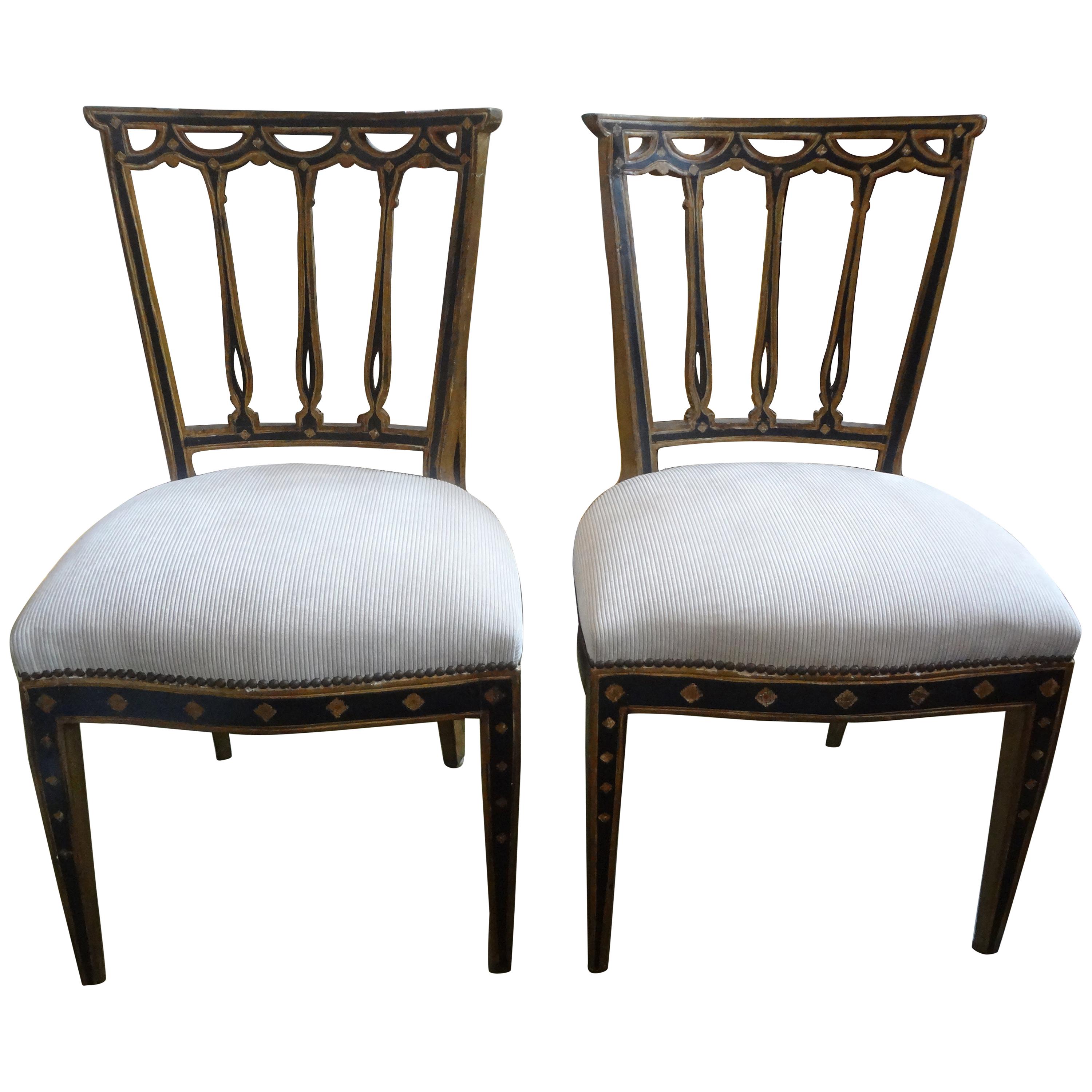 Stunning pair of Italian neoclassical style black and giltwood chairs from Florence. These stylish Italian giltwood side chairs are comfortable and elegant. They have been professionally upholstered in a plush striated cut velvet fabric with brass