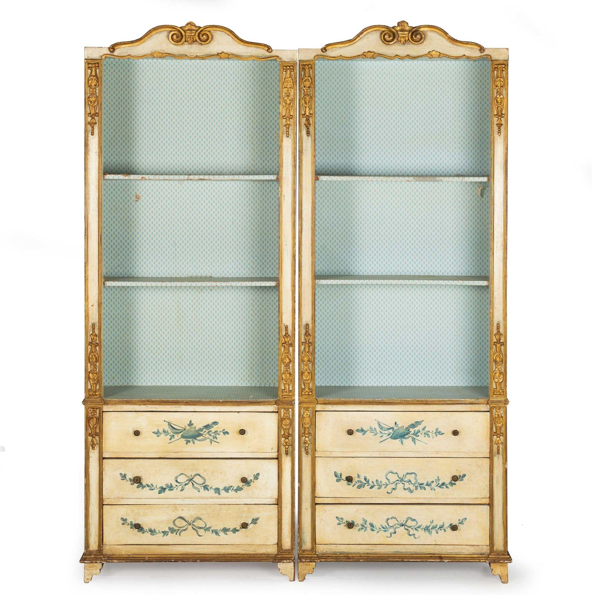 A delightful pair of 20th century bookcases in the Italian Neoclassical taste, they are whimsical and fun with applied giltwood moldings over nice paint decorated surfaces. They are comprised of an upper open bookshelf area with adjustable shelving