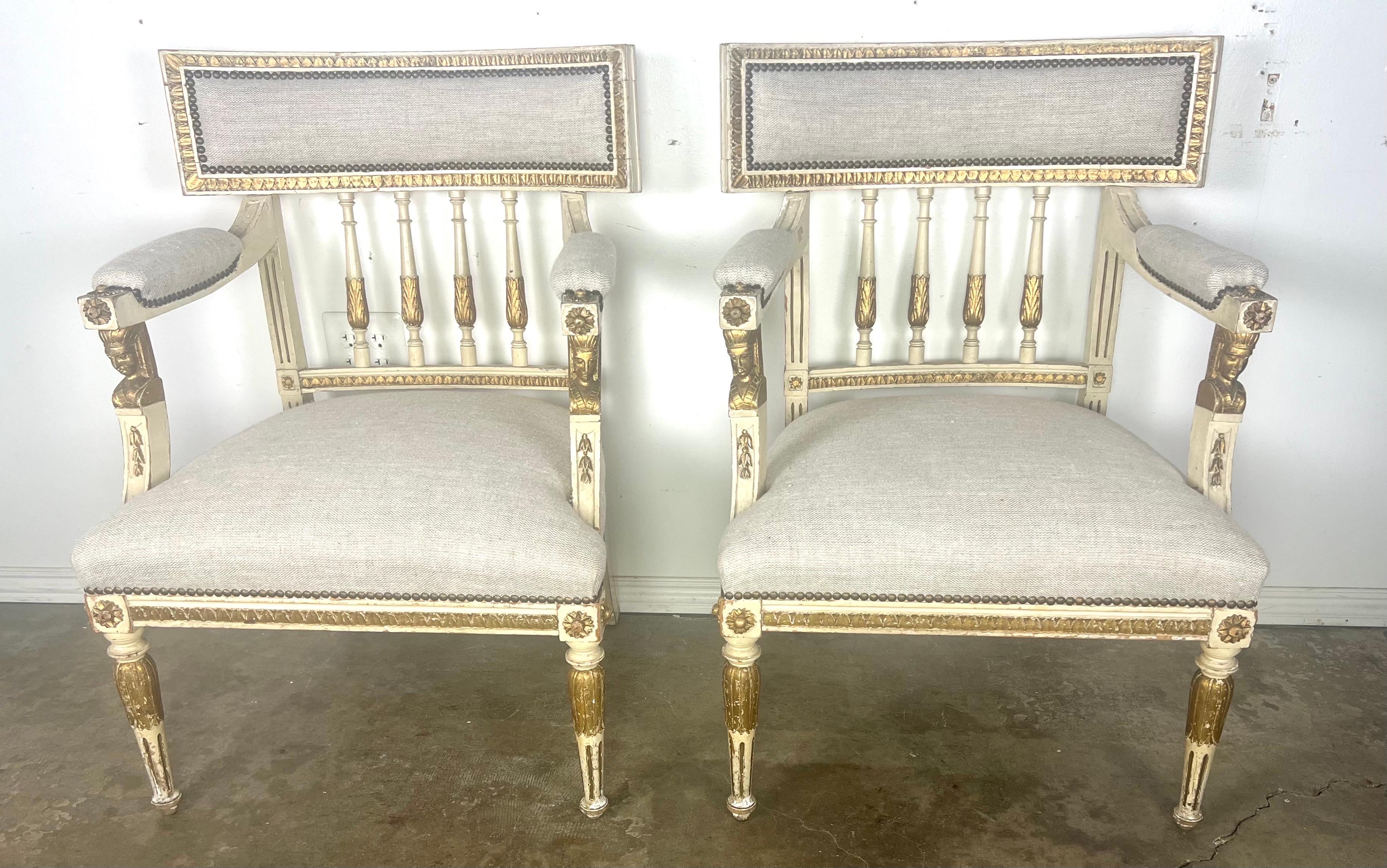 Fauteuils italiens de style néoclassique avec une finition peinte et dorée parcellaire.  Ce style se caractérise par ses éléments néoclassiques,  y compris les lignes droites, les pieds cannelés et les sculptures complexes.  Les accoudoirs