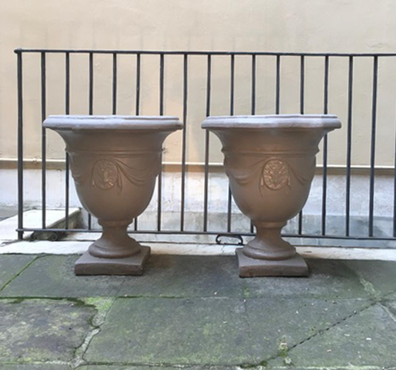 This is a pair of Italian gardens urns made in agglomeration of sand of stones, stone sable add to the cement. 
The result is a mixture very strong and resistent to the bad weather, but less expensive than a marble urns in the same dimensions. To