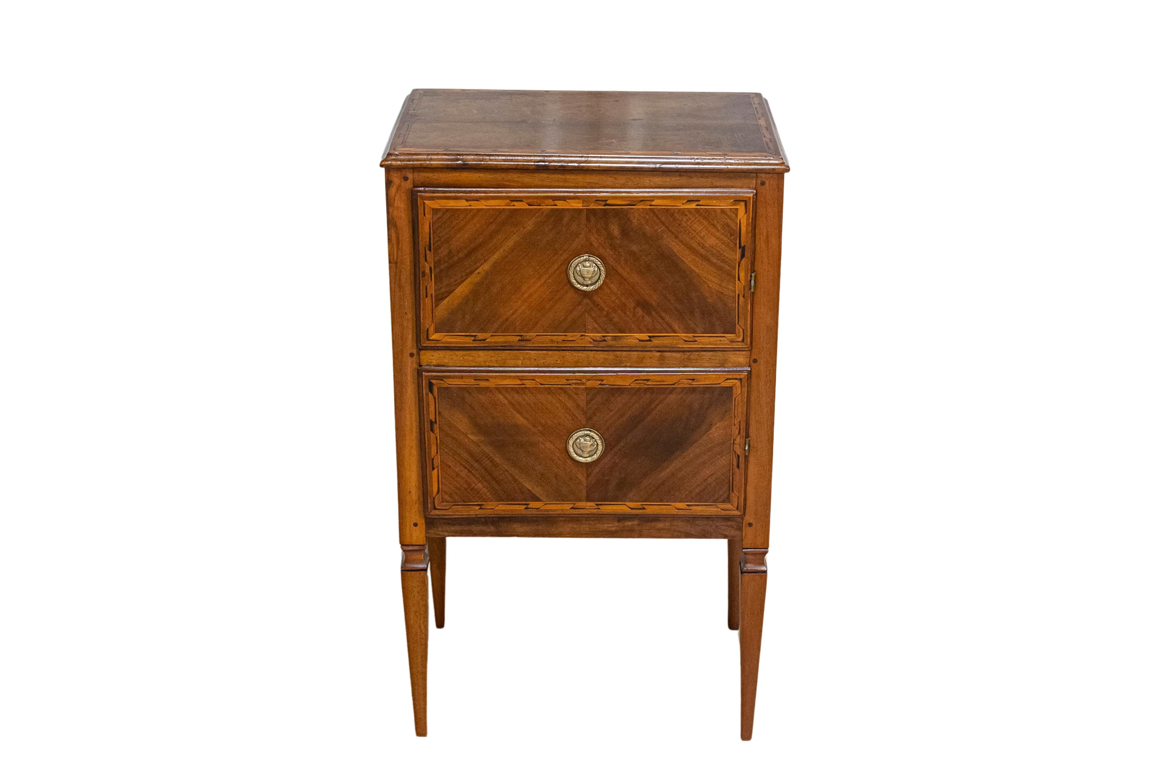 A pair of Italian Neoclassical style walnut bedside chests from the 19th century with two drawers and tapered legs. Crafted during the 19th century in Italy, this pair of Neoclassical nightstands exudes timeless elegance. Their walnut construction
