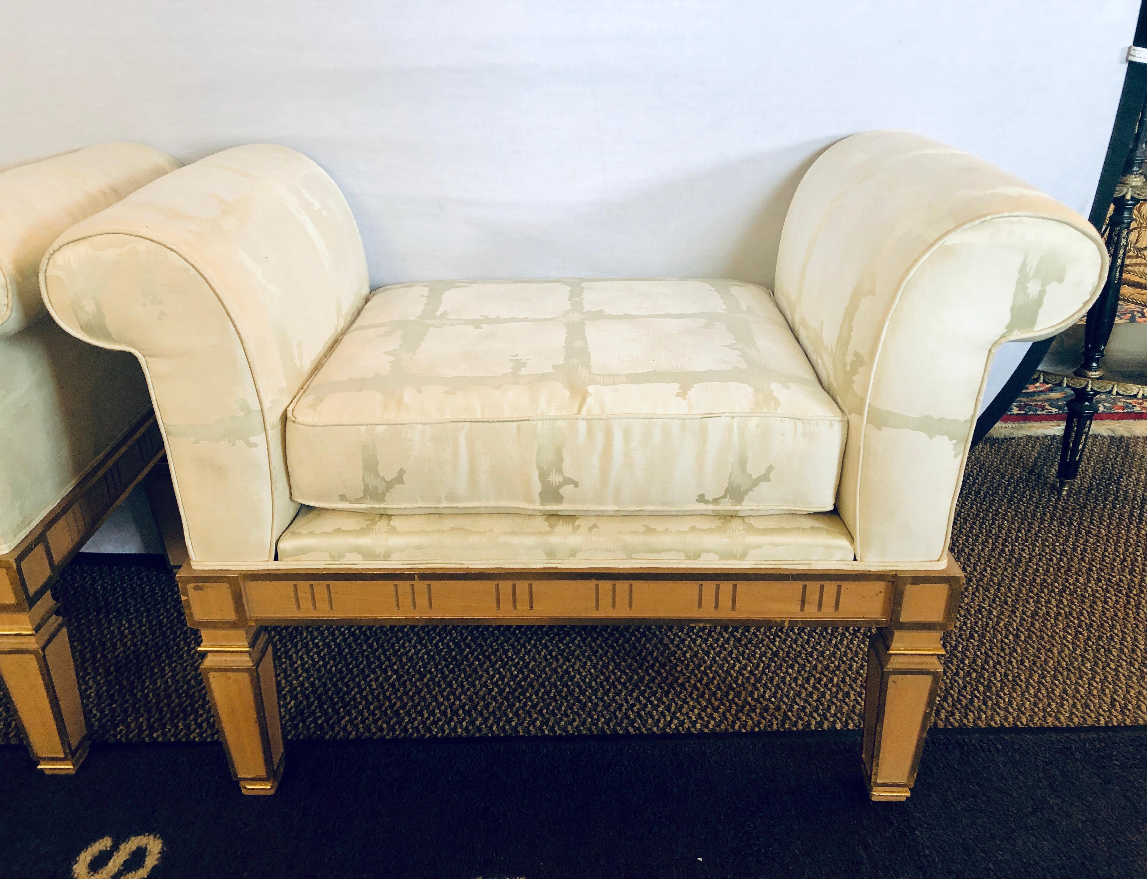 Pair of Italian neoclassical style window benches crème painted with gilt highlights.