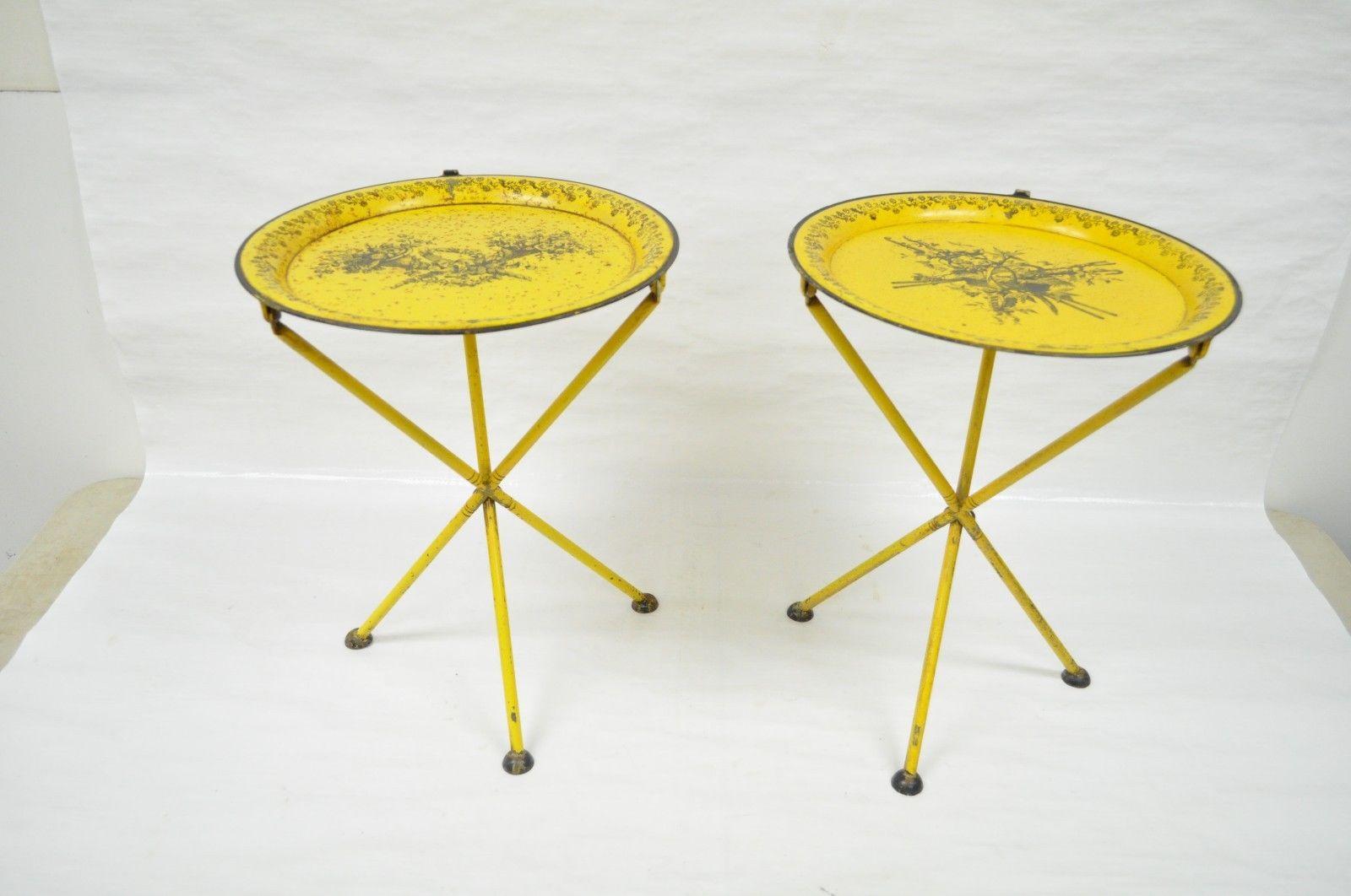 Pair of vintage Italian neoclassical style tole metal small folding side tables. Item features metal frame, folding design, harvest depictions, yellow painted finish, round drop rings (Can be used to hang on a wall), marked, Italy, circa 1950s,