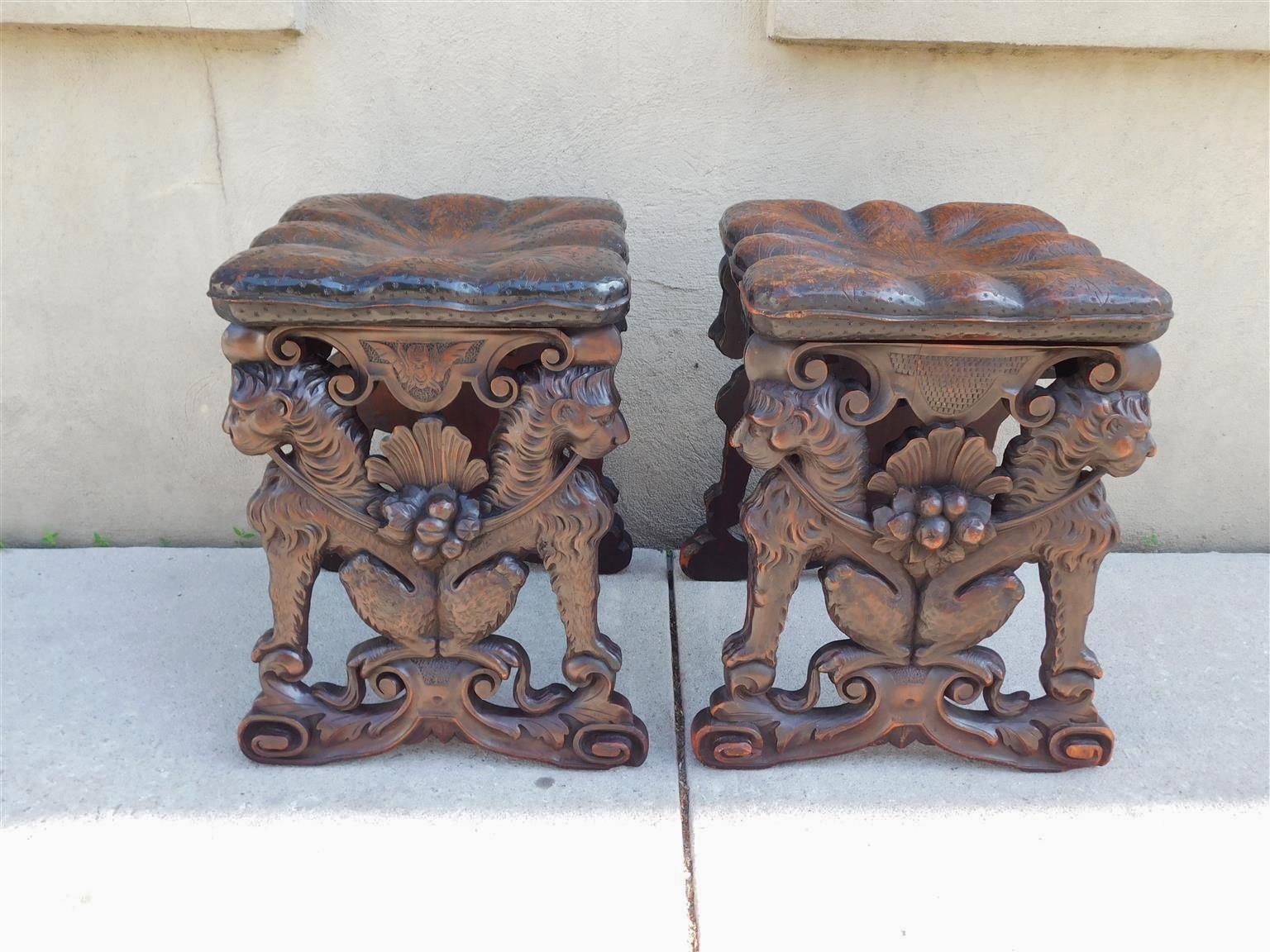 Pair of Italian Neoclassical walnut flanking figural lion pillow top stools with central shell fruit carvings, and resting on acanthus foliate scrolled legs, Early 19th Century
