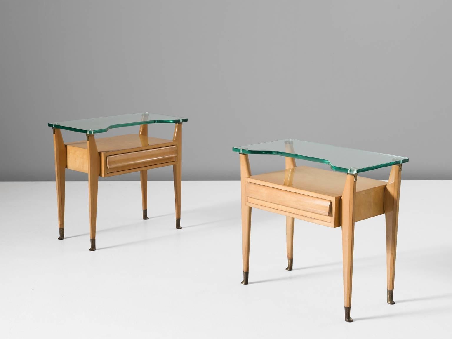 Nightstands, birch, glass and brass, Italy, 1950s.

These two side tables or nightstands are both refined and elegant in every way. The glass top stretches a little but over the outer edges of the solid, precisely crafted oak legs. These sculptural
