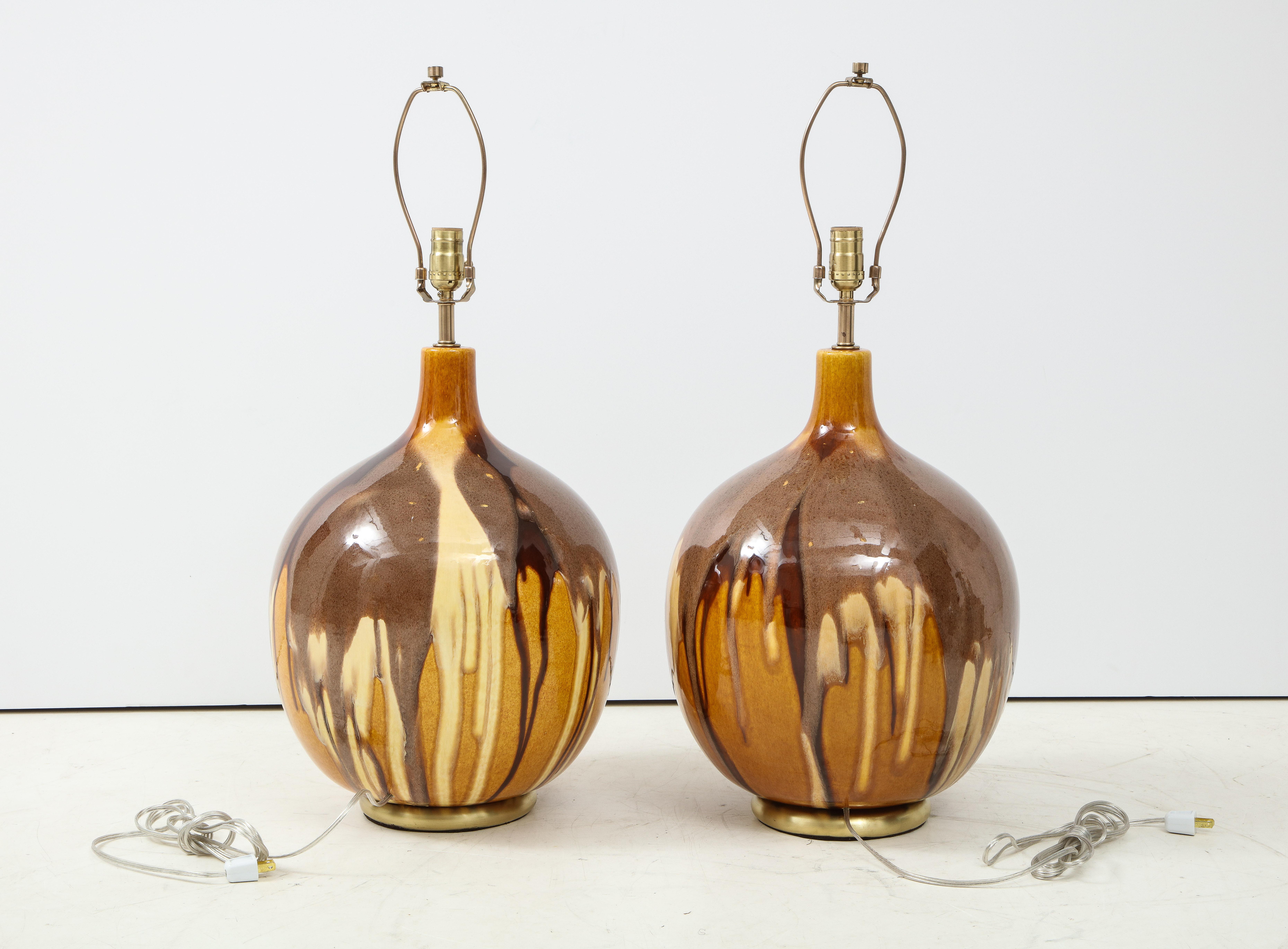 Pair of Italian midcentury earth tone glazed ceramic lamps featuring ochres and Sienna on aged brass bases, circa 1960s. Rewired for use in the USA, 100W max bulbs.