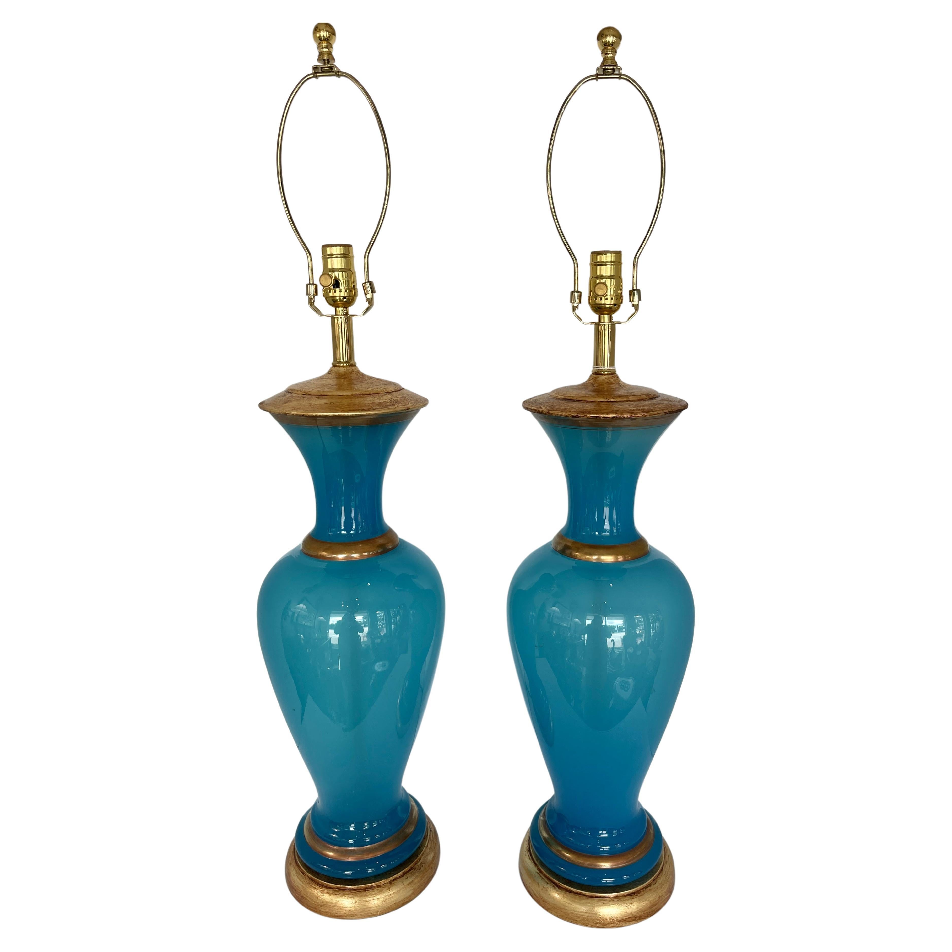 Paire de lampes de table italiennes en verre bleu opalin.
Ces lampes sont en verre opalin bleu avec un revêtement en plastique.  détails dorés sur le verre, la base et le couvercle en laiton.
Ces lampes sont en état de marche et leur câblage a été
